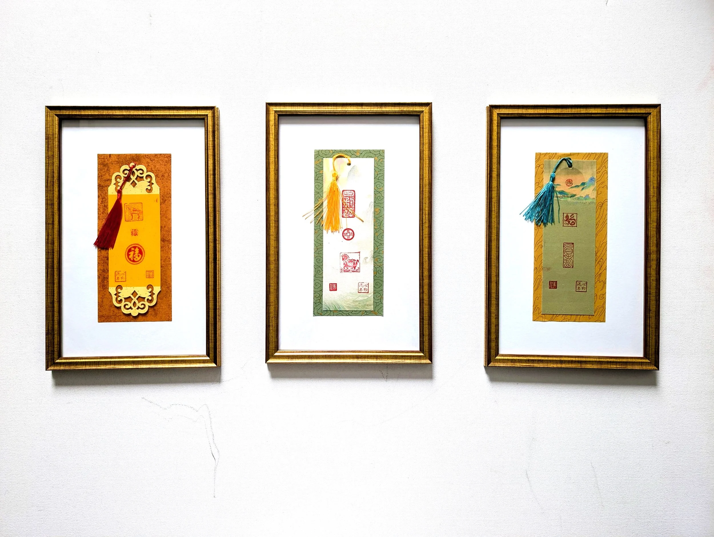 Three framed XINYIN LIUNIAN® | 心印流年 bookmark artworks by Jingmin Ren 任静敏, combining Chinese seal impressions, decorative forms and tassels.