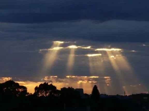 Sunrays breaking through dark clouds over Sydney, photographed by Jingmin Ren during her sunrise observations.