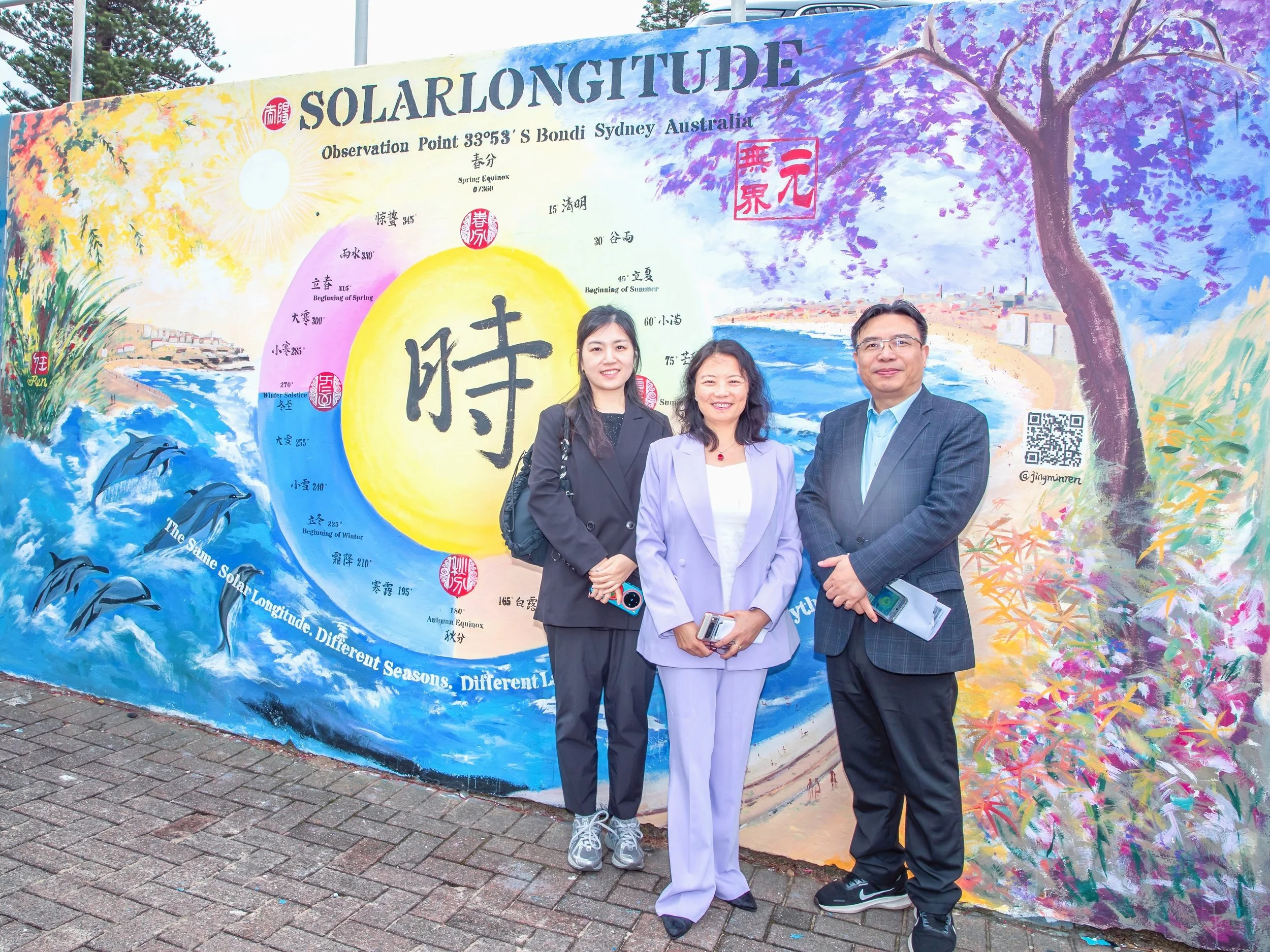 Artist Jingmin Ren with Chinese Cultural Counsellor Le Liwen and Consul Cheng Hanjun in front of her Solar Longitude – Time Orbit public mural at Bondi Sea Wall, Sydney. 艺术家任静敏与中国驻悉尼总领馆文化参赞乐利文、领事程汉君在悉尼邦迪海墙公共壁画《太阳黄经－时间轨道》前合影。