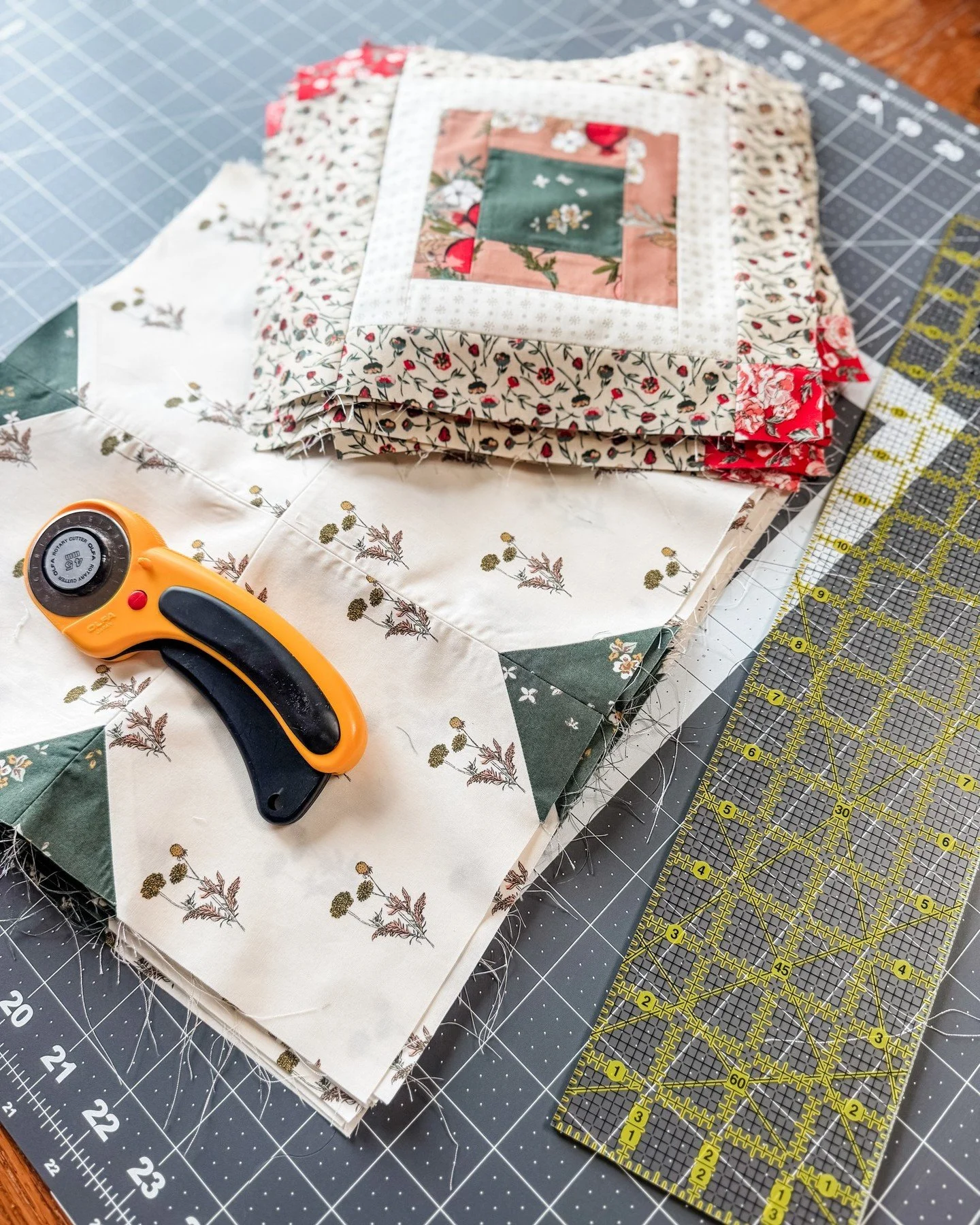These Clover blocks are finished.

Tucked under the unfinished Magnolia pieces I showed you yesterday, you can see the triangle shapes along the edges. Those will become part of diamond shapes in the overall design of the quilt once everything is ass