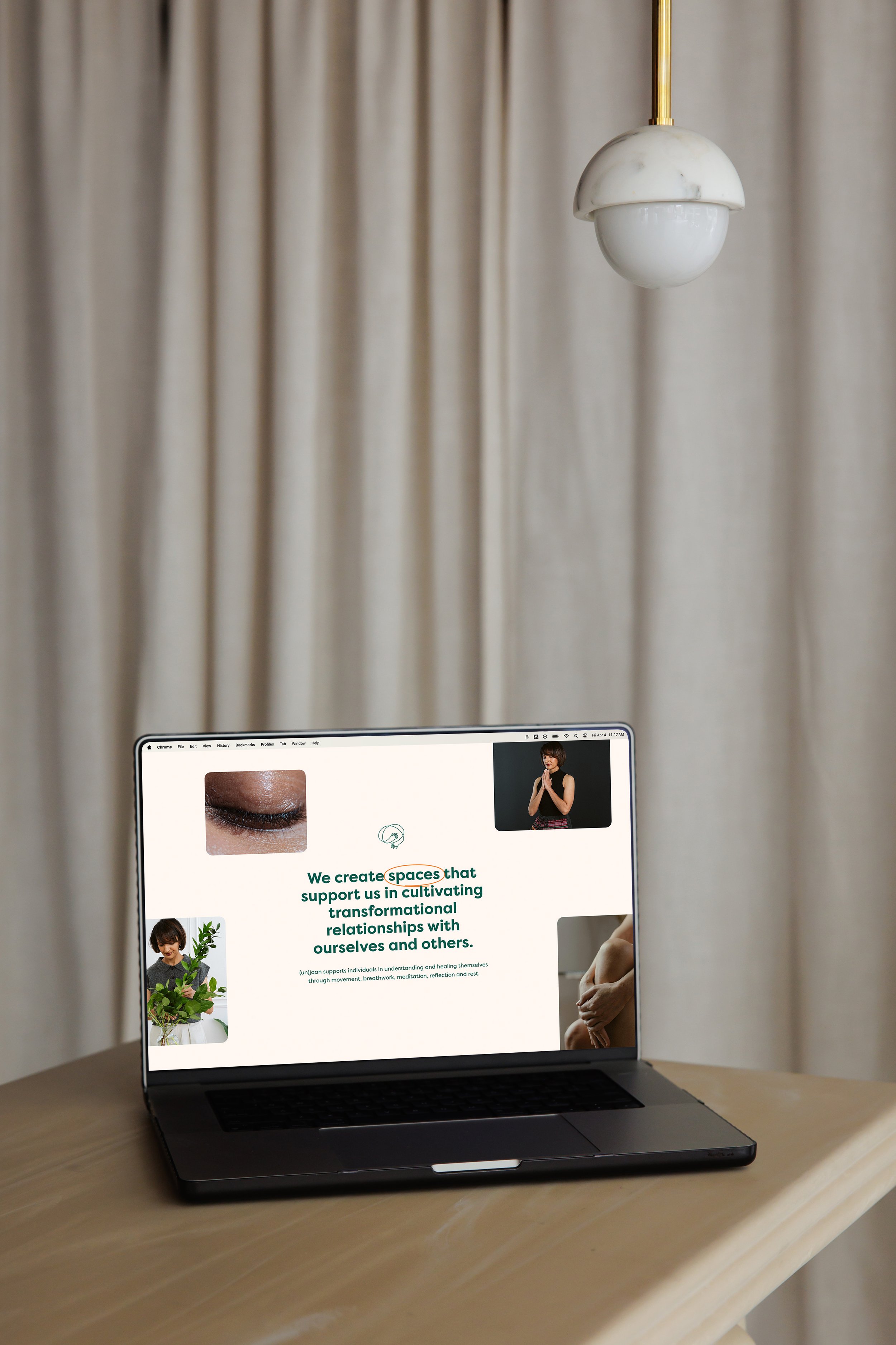 Open laptop on a wooden table displaying a webpage about supporting transformational relationships, with images of a closed eye, a woman, a girl holding a plant, and a person hugging their knees, in a room with beige curtains and a hanging white marble lamp.