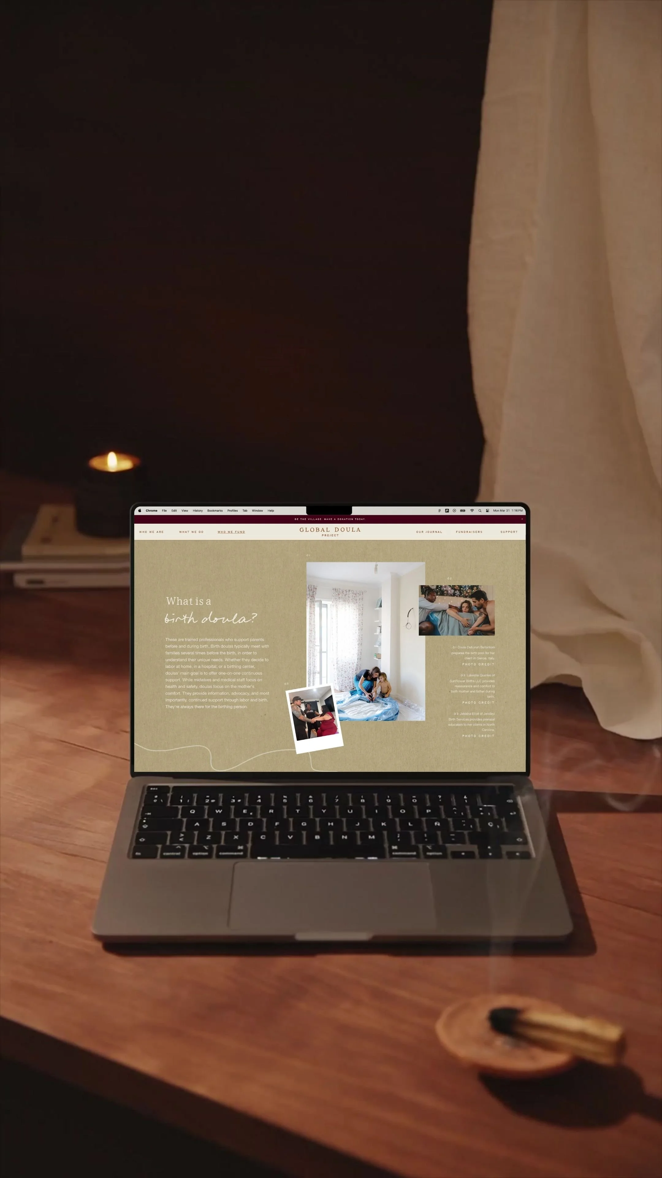 Laptop on wooden desk displaying a website about birth doulas with images and text. A lit candle and incense holder are on the desk.