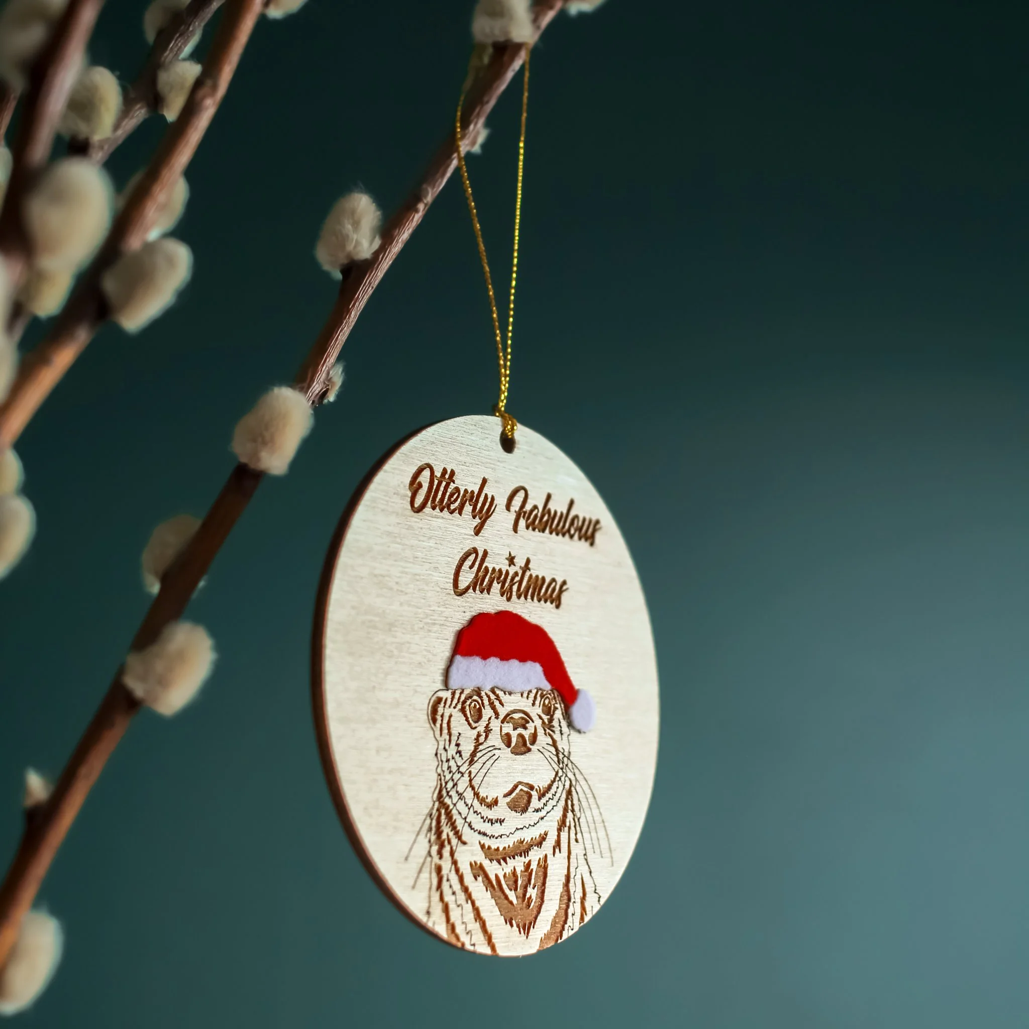 Side view of hanging Otter ornament. The mix of texture and layers add interest to this handcrafted, original piece designed and made by a small business based in the UK.