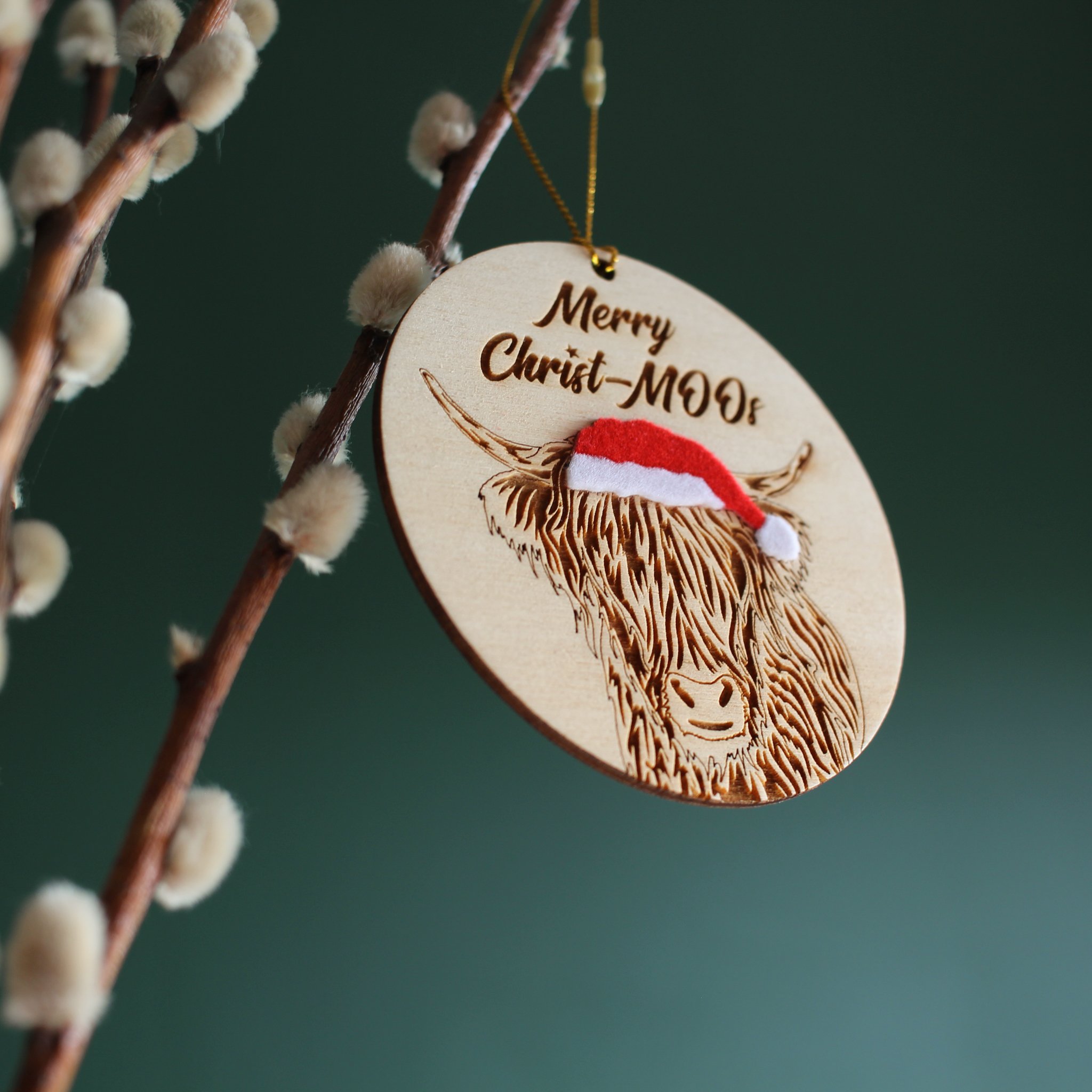 Oblique, upward view of hanging highland cow ornament. The mix of texture and layers add interest to this handcrafted, original piece designed and made by a small business based in the UK.