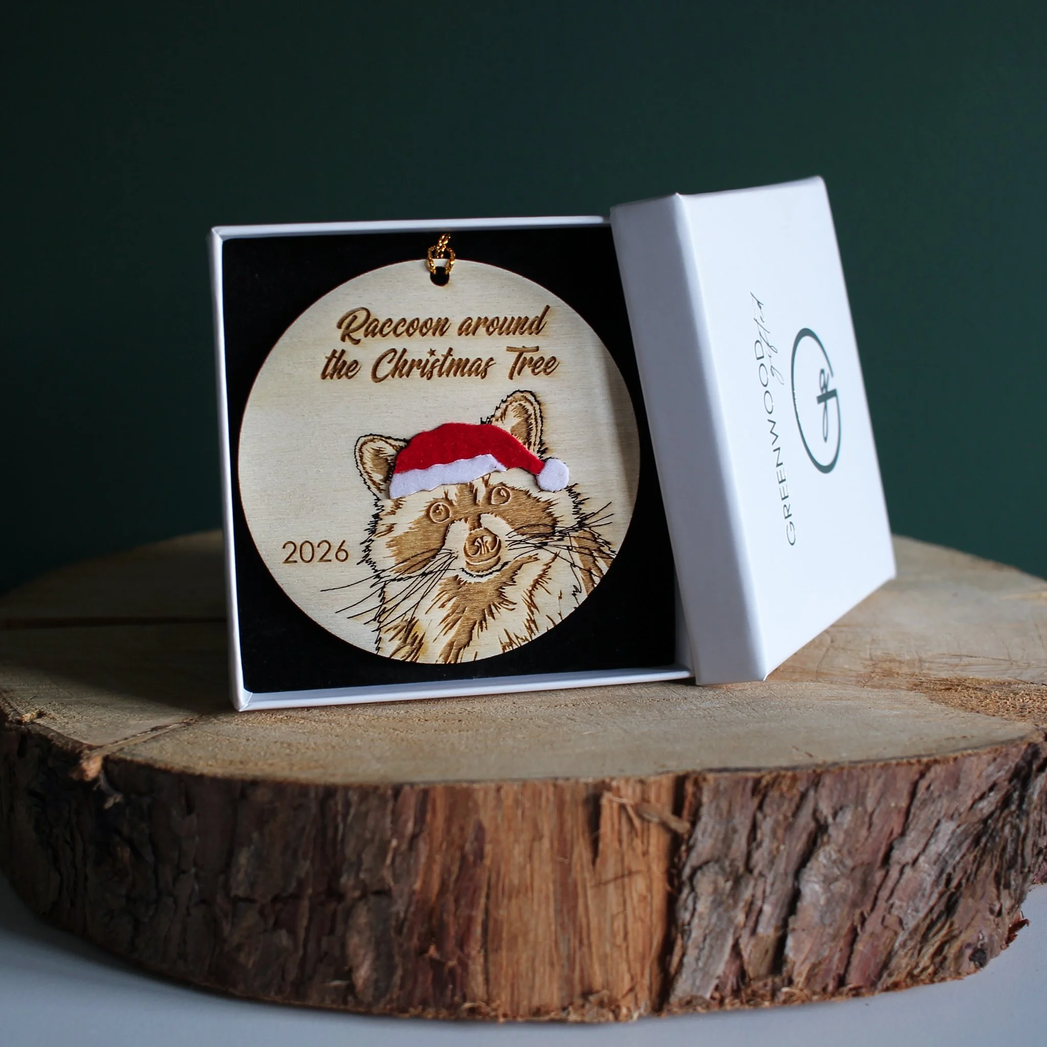 Wooden raccoon Christmas ornament with optional 2026 year engraving, presented in a white Greenwood Gifted gift box with black insert.