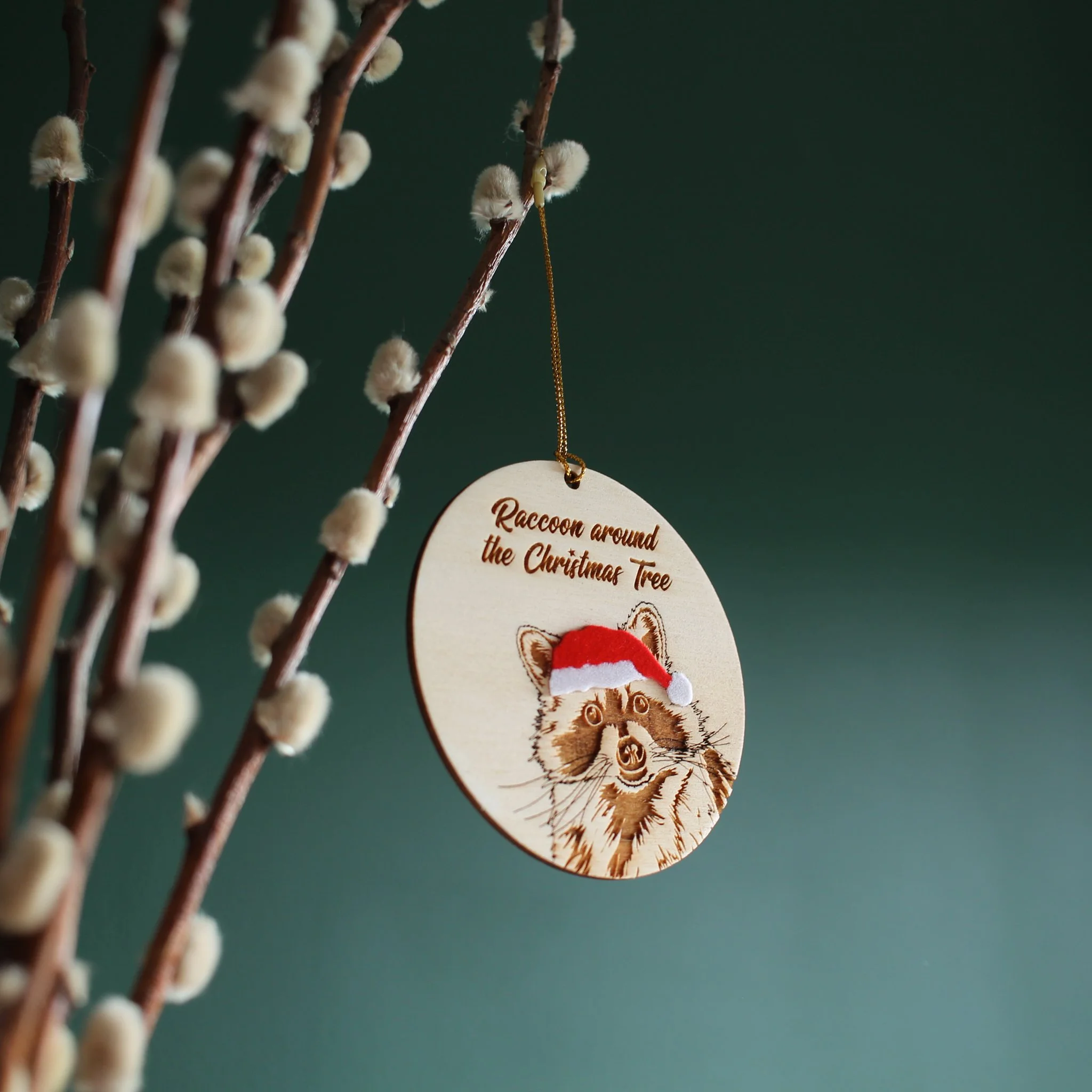 Side view of hanging raccoon ornament. The mix of texture and layers add interest to this handcrafted, original piece designed and made by a small business based in the UK.