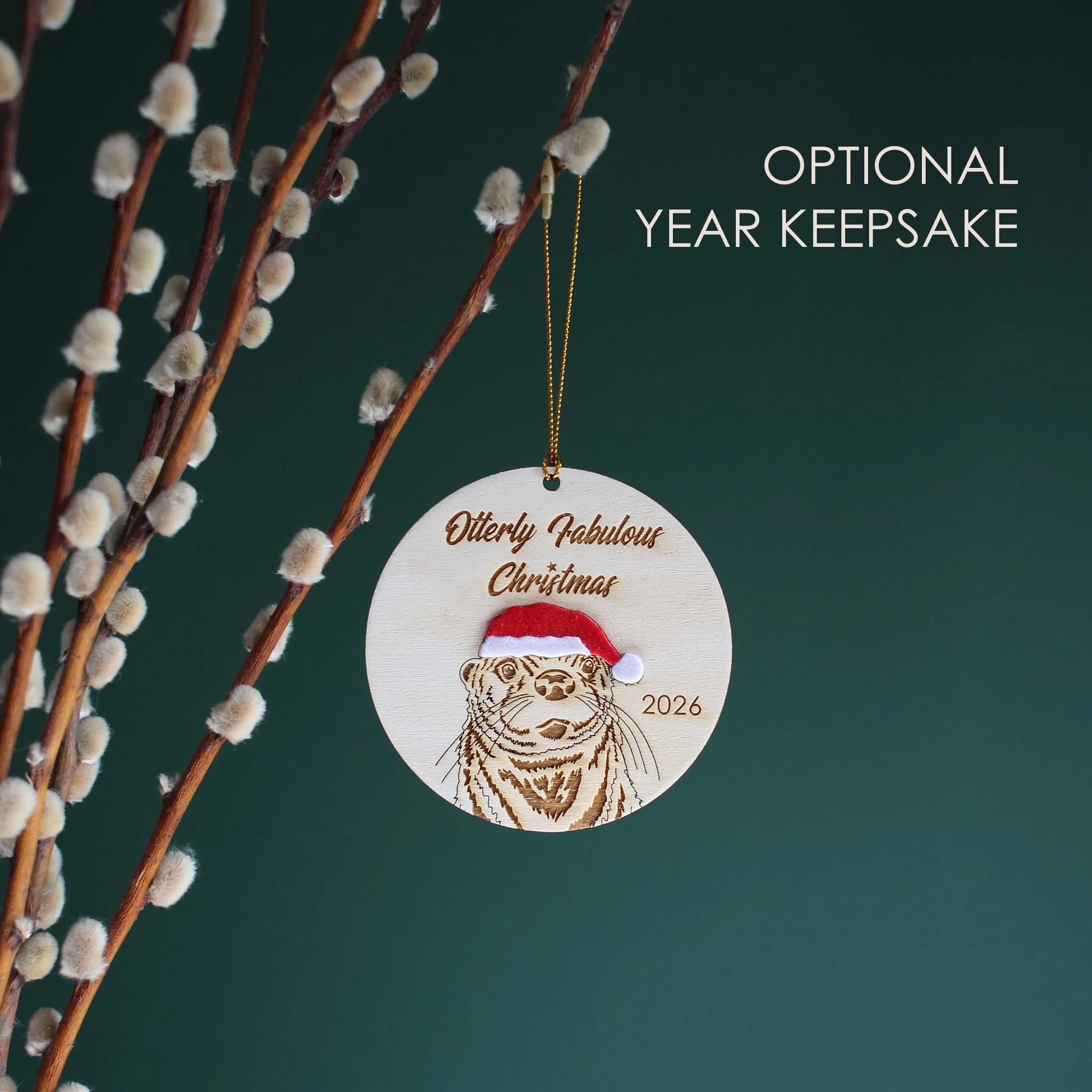 Wooden Otter Christmas ornament with optional 2026 year engraving, featuring an original hand-drawn otter in a Santa hat and festive Christmas pun.