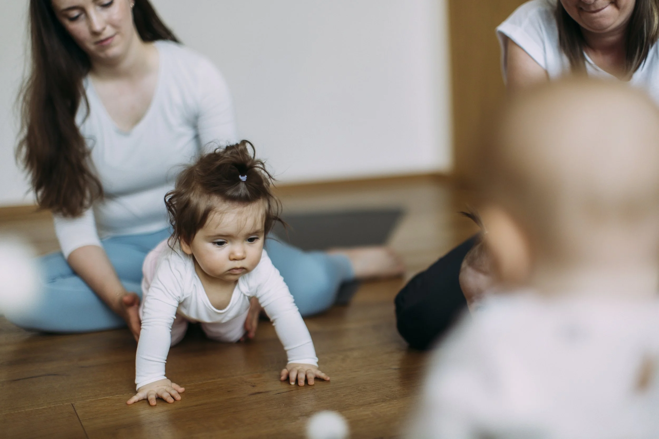 Miminko kolem 6 měsíců během lekce BabYogy procvičuje otáčení kolem své osy, pivotování a přípravu na lezení v rámci podpory psychomotorického vývoje v MIMAMI Space na Praze 4 v Nuslích.
