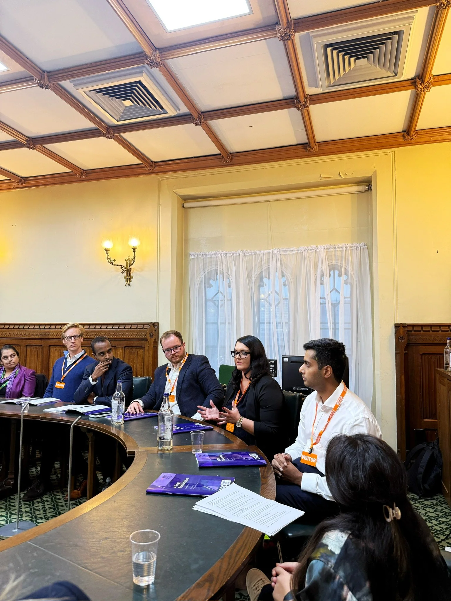 A panel discussion in a parliamentary room with attendees seated around a curved table. From right to left: Arun Veerapan, Emma Partlow, Alister Crisp, and Dr Arun Ulahannah participating in conversation.