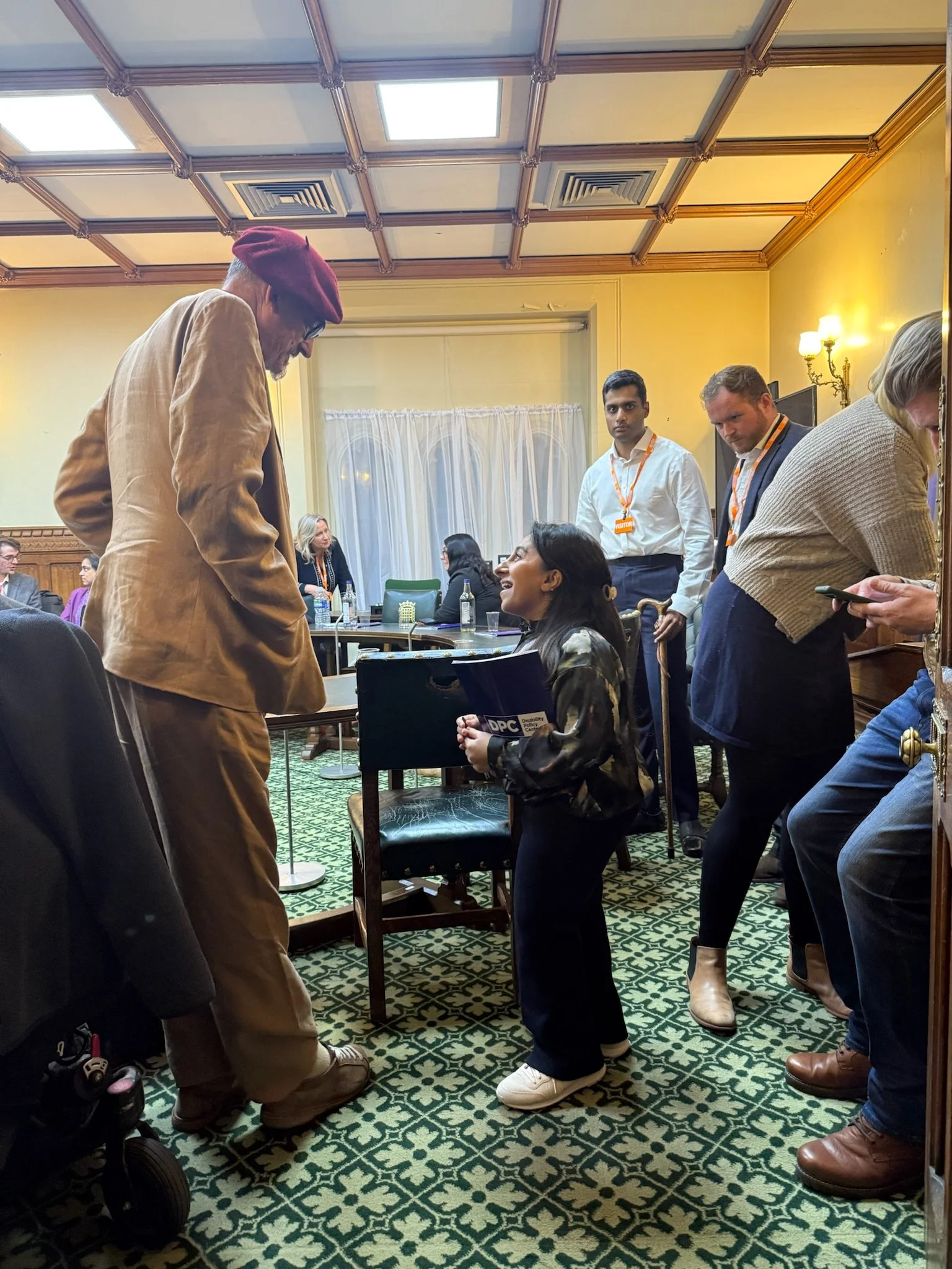 Host Dr Shandi is stood up speaking an attendee and the end of the panel. Other speakers Arun, Alistair and Louise can be seen in the background also mingling. 