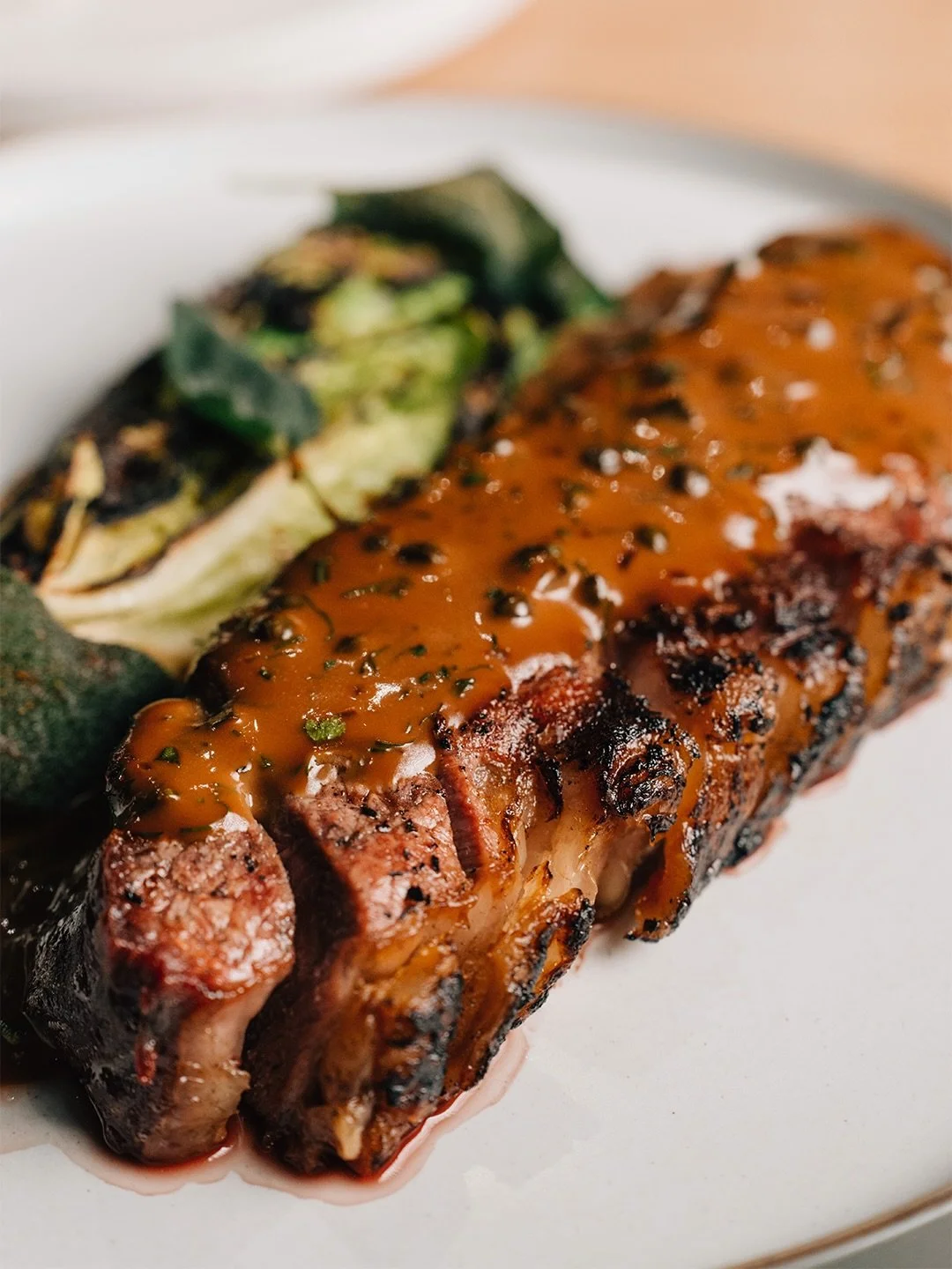 Have you tried our Longhorn flat iron steak?
Cooked over open fire, where flame and smoke bring out deep, rich flavour 🔥

This Longhorn flat iron is cooked on the hearth, finished with our house charcuterie sauce and paired with grilled gem lettuce 