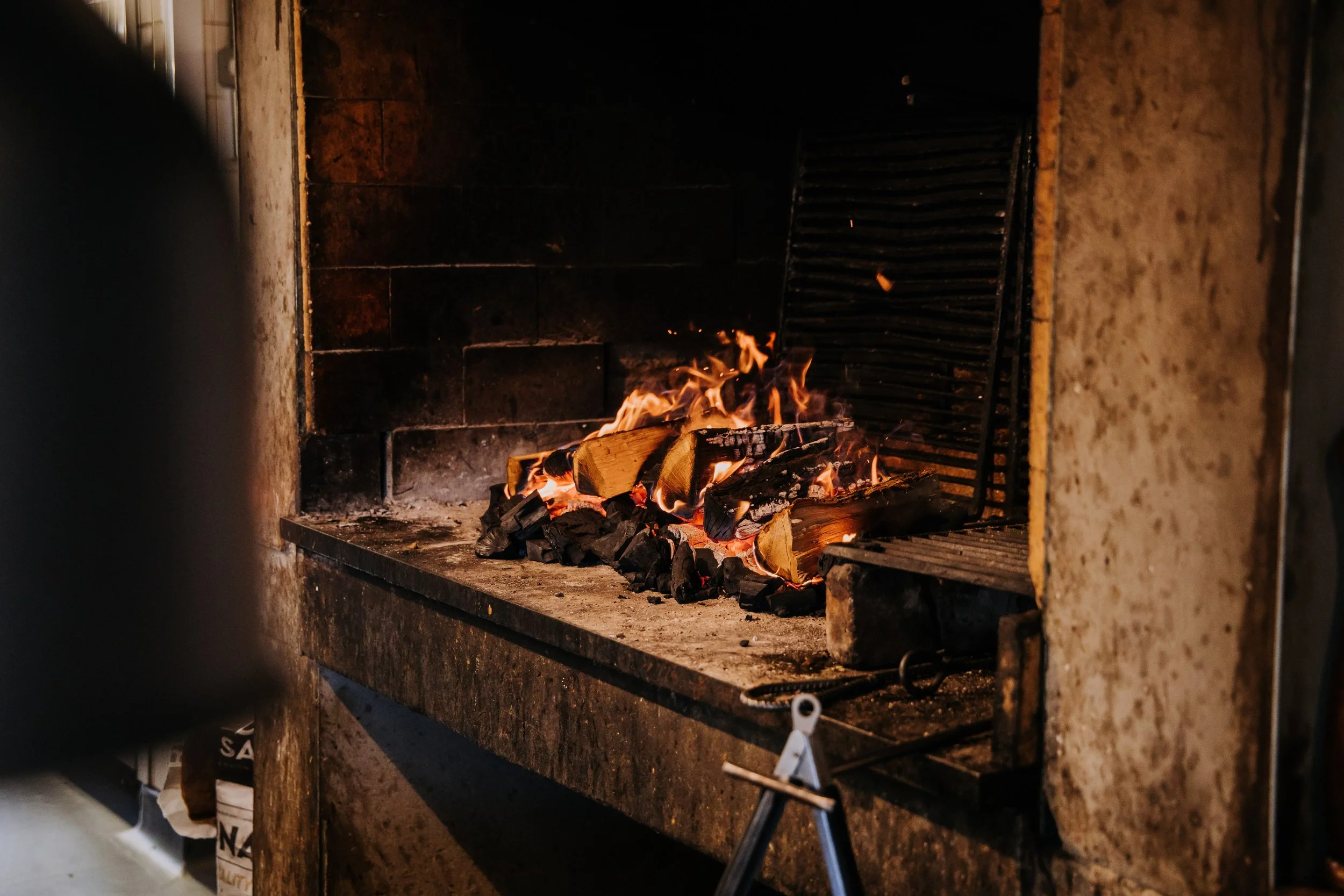 A fireplace with burning logs and flames.