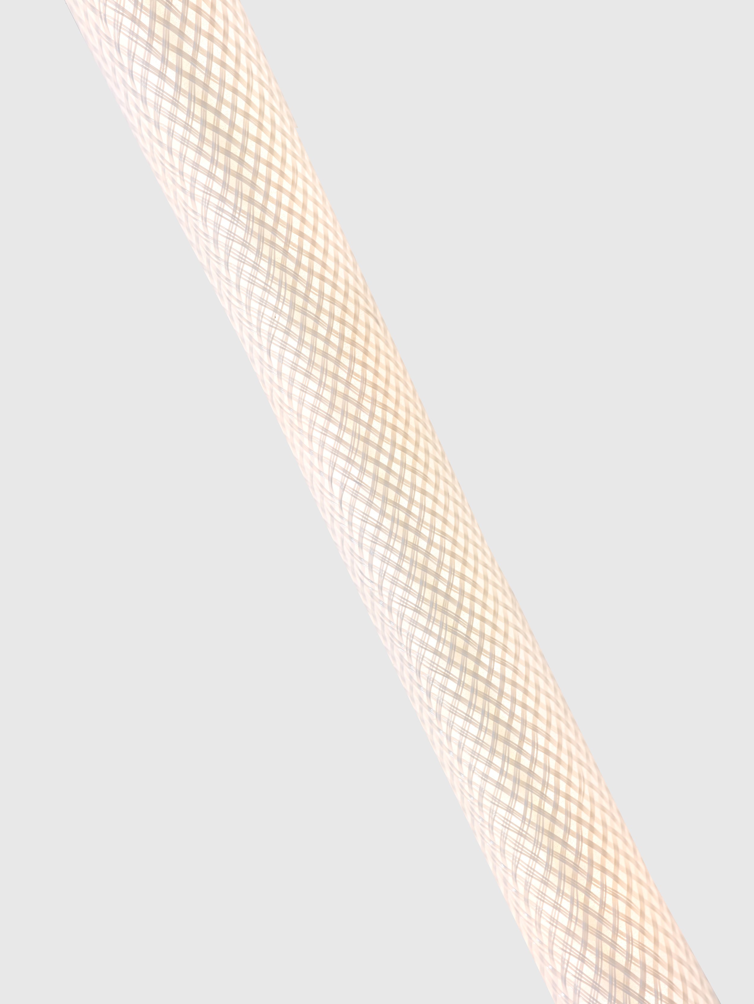 Close-up of a textured, woven material in a crosshatch pattern on a cylindrical surface.