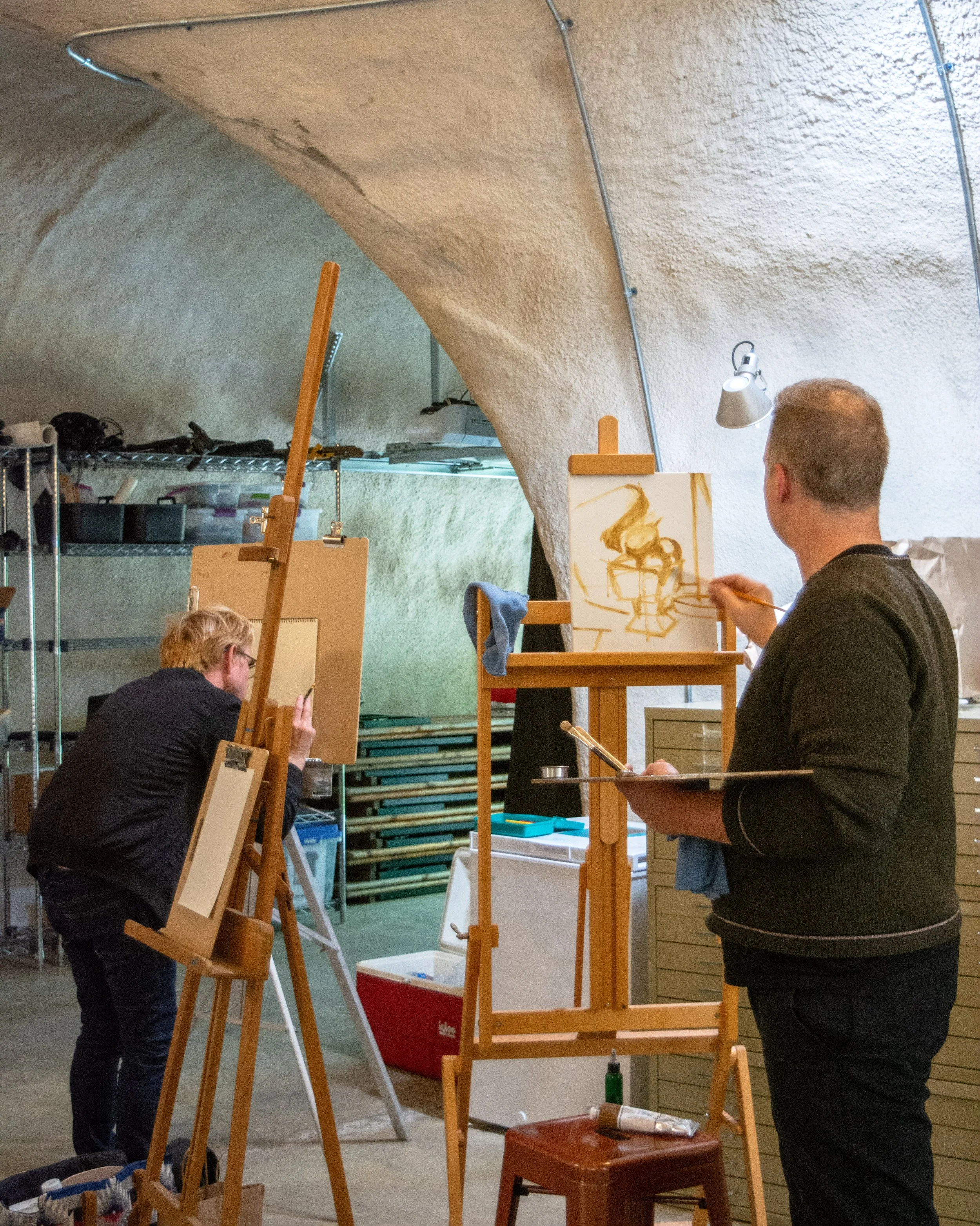 Two artists, one being Douglas Pendleton painting on canvases in an art studio at the Dome House 