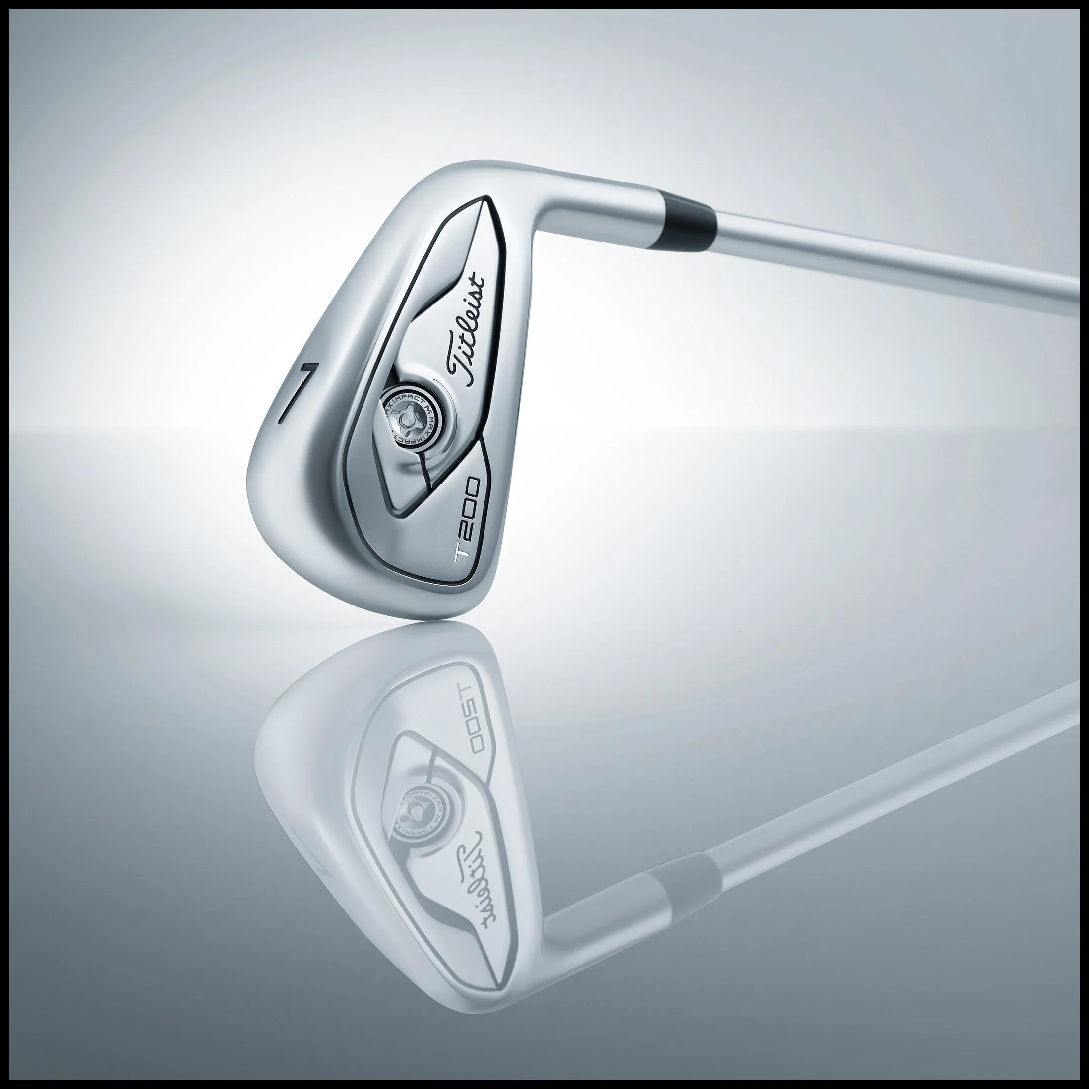 Close-up of a silver Titleist T200 golf iron club with a reflection on a smooth surface.  Titleist Golf T200 Golf Iron White Product Advertising Photography KyleSmithPhoto.
