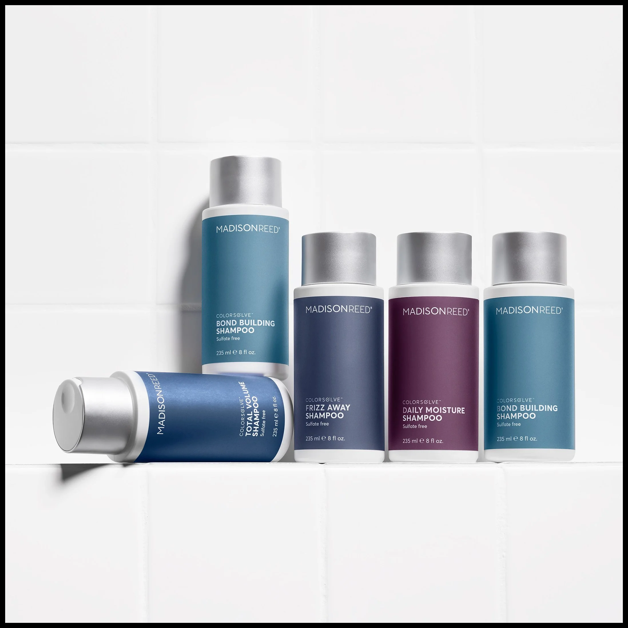 Set of five Madison Reed hair care products including shampoo bottles and a conditioner bottle, arranged on a white tiled surface.
