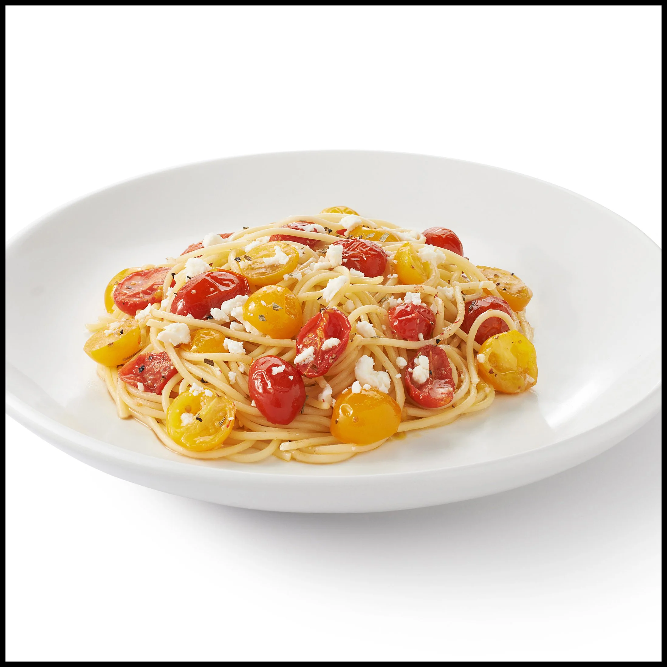 Plate of spaghetti pasta with cherry tomatoes and white cheese