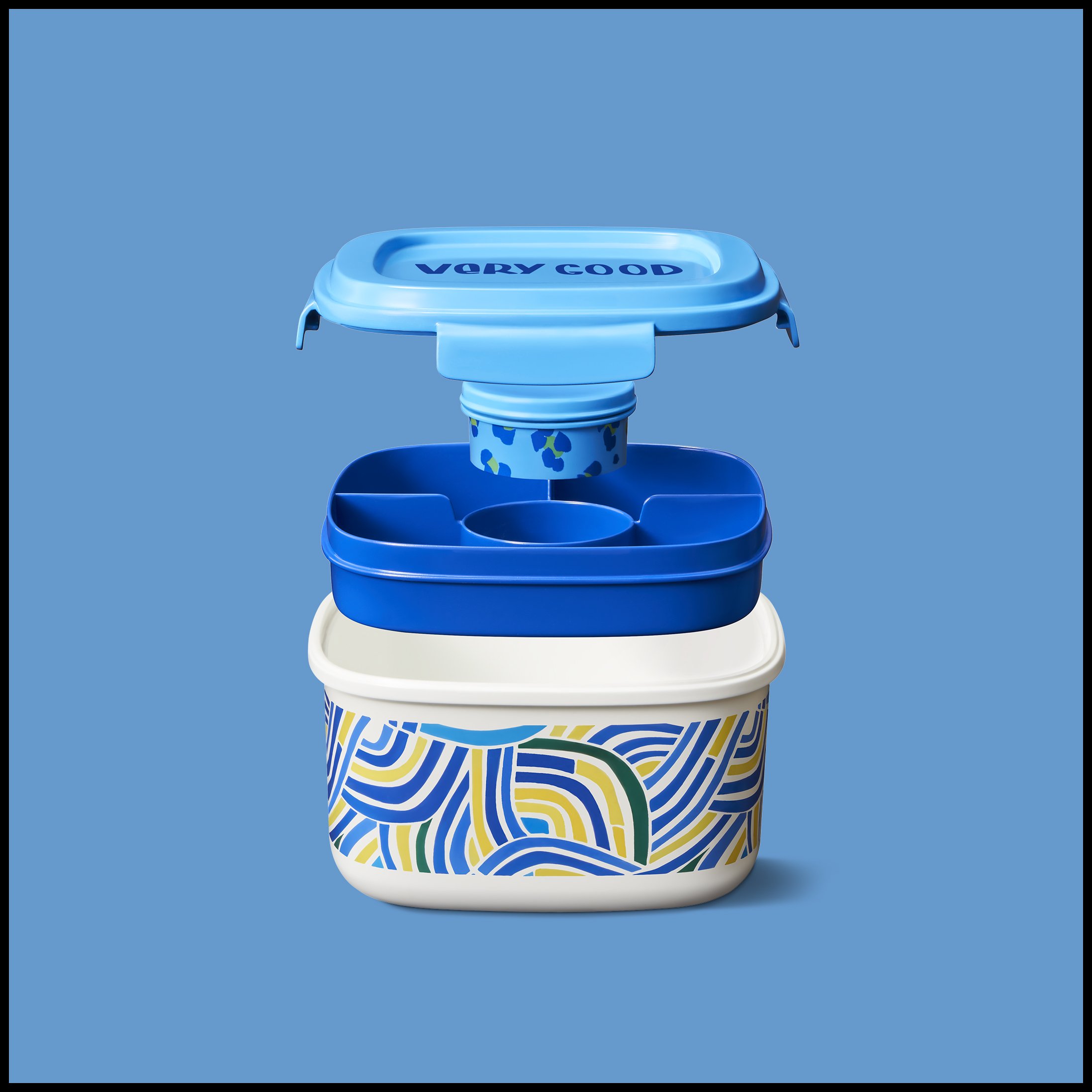 An open bento box with colorful abstract patterns on the outside, and an upper container with the words 'Very Good' on the inside lid, floating above a smaller blue container with sections inside.  Target Food Storage Portable Salad Container.