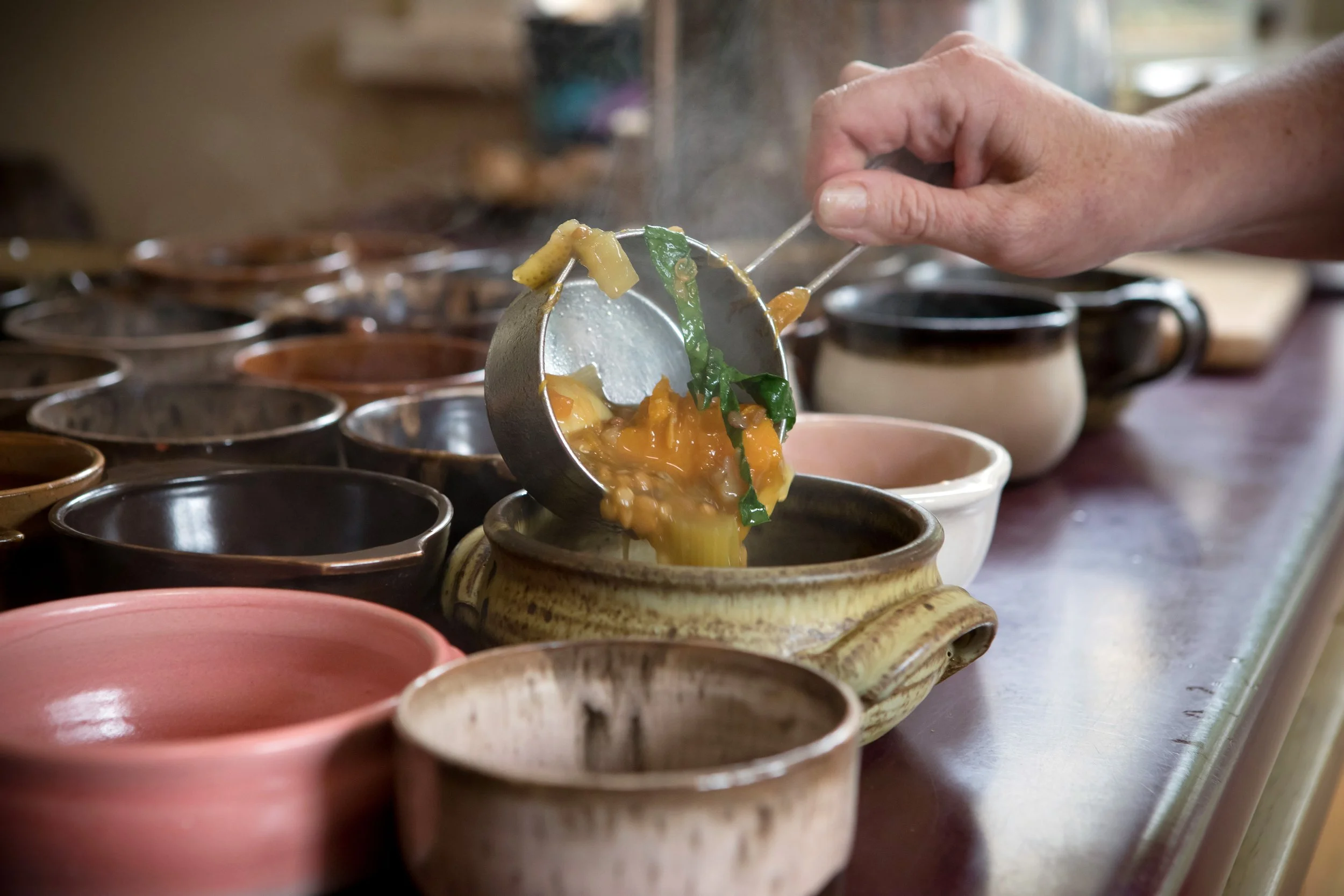 Vegetable soup poured into small pottery soup bowls
