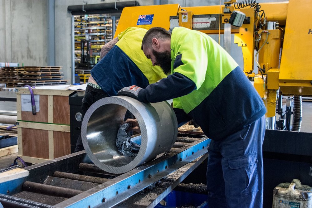 Two Processing Officers work on a Stainless steel hollow bar in the Bibra Lake, W.A warehouse