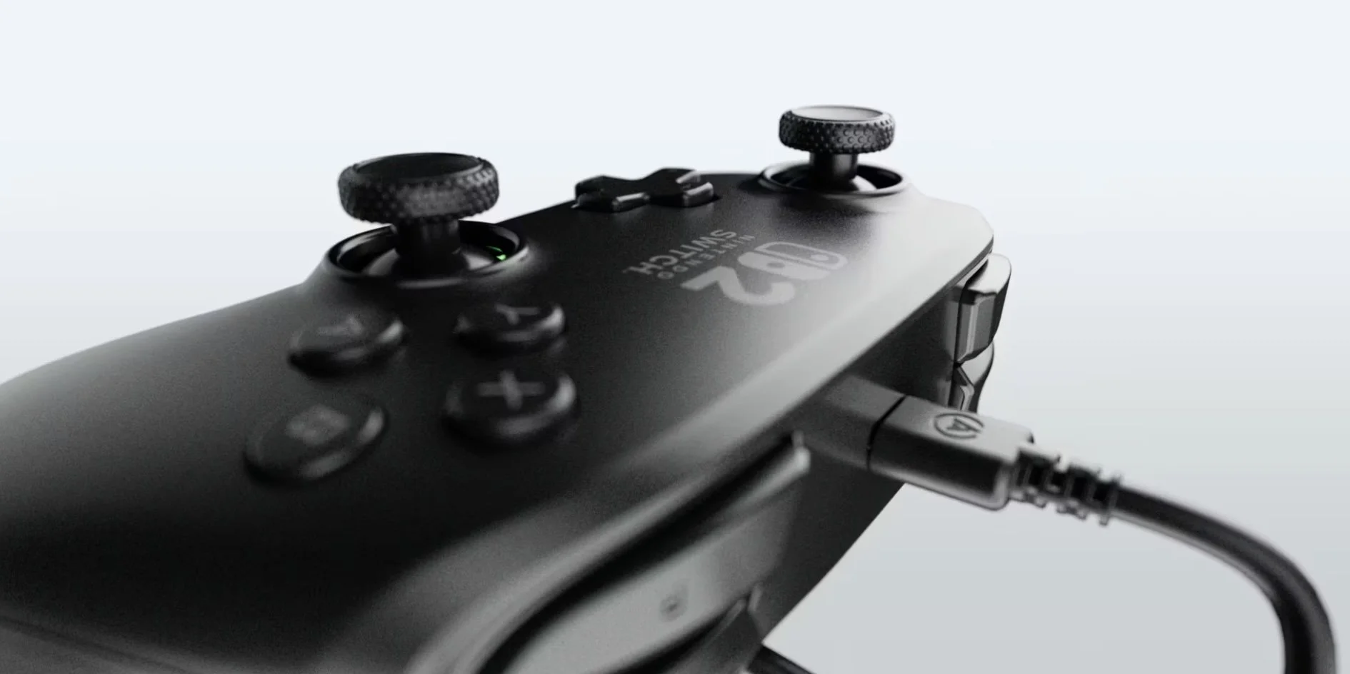 Close-up of a nintendo switch 2 black gaming controller connected to a device via a wired cable, with textured thumbsticks and control buttons visible. 3D animation render studio.