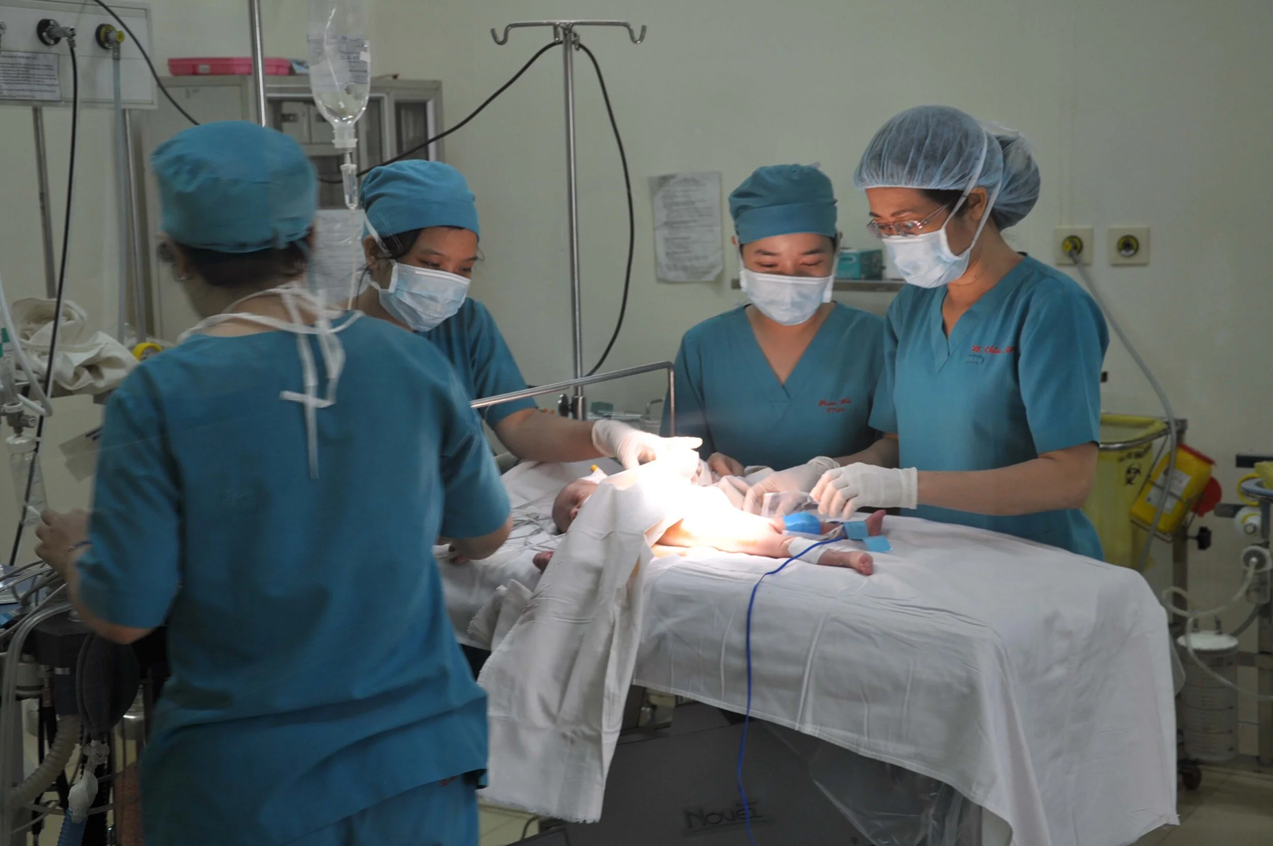 4 Ärztinnen operieren ein Neugeborenes in Vietnam