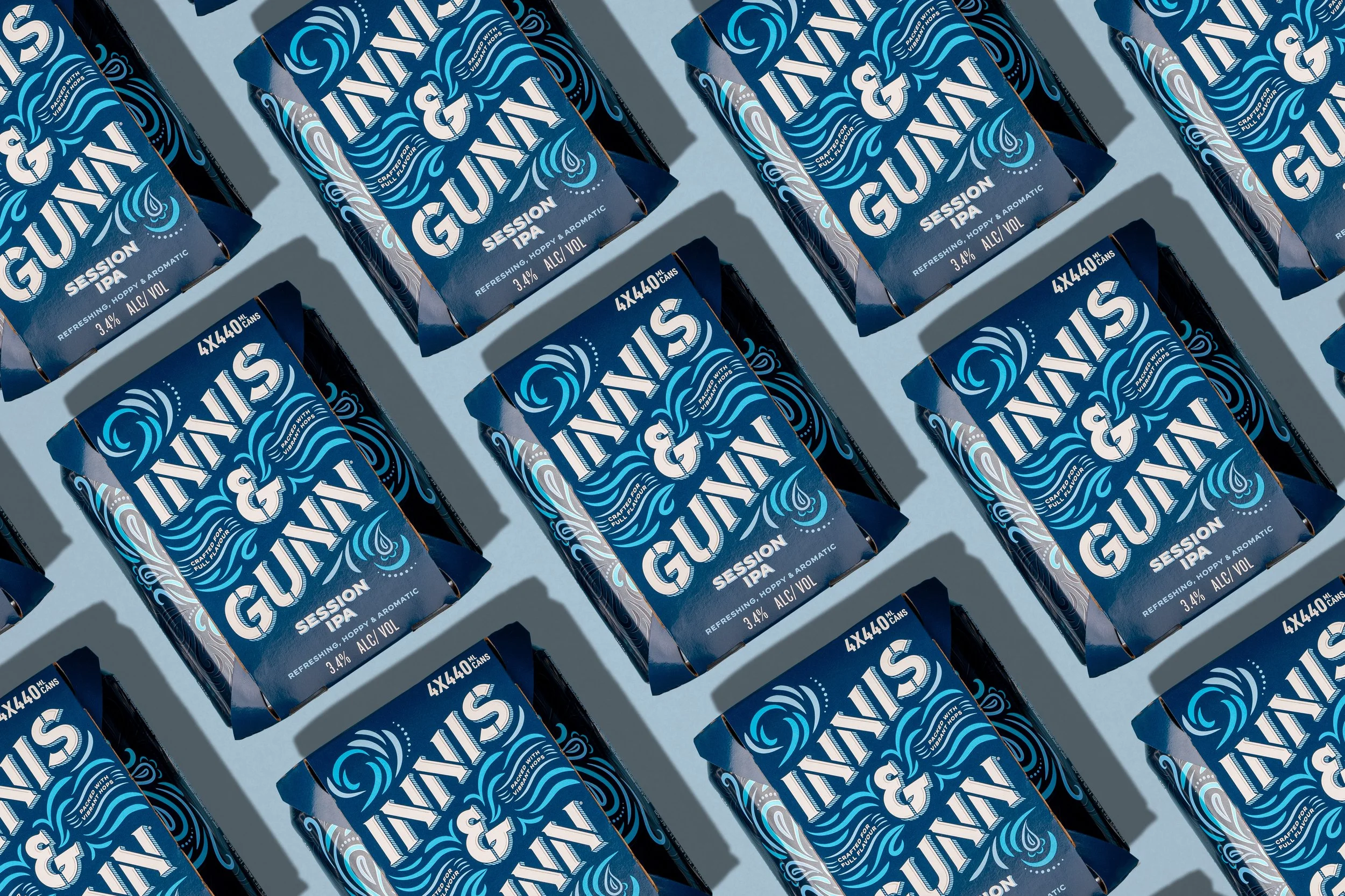 Multiple packs of Innis & Gunn Session IPA beer arranged in a diagonal pattern on a flat surface.