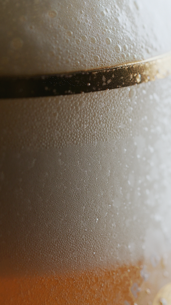 Close-up of a cold beer glass with condensation and a dark line on the glass.