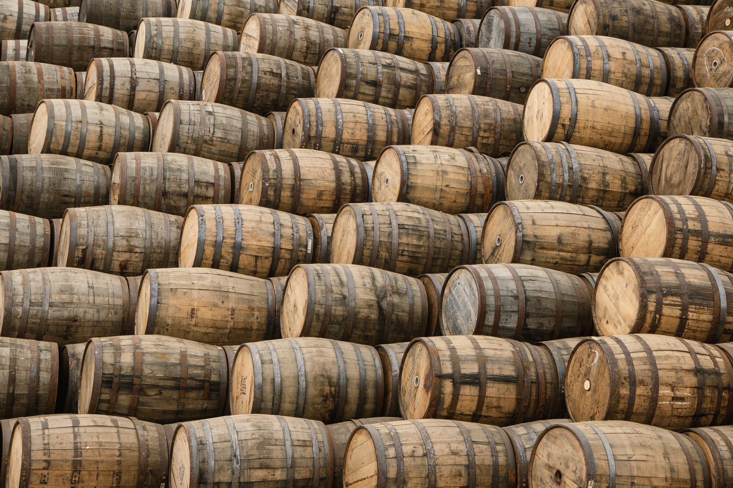 Numerous wooden barrels stacked in rows.