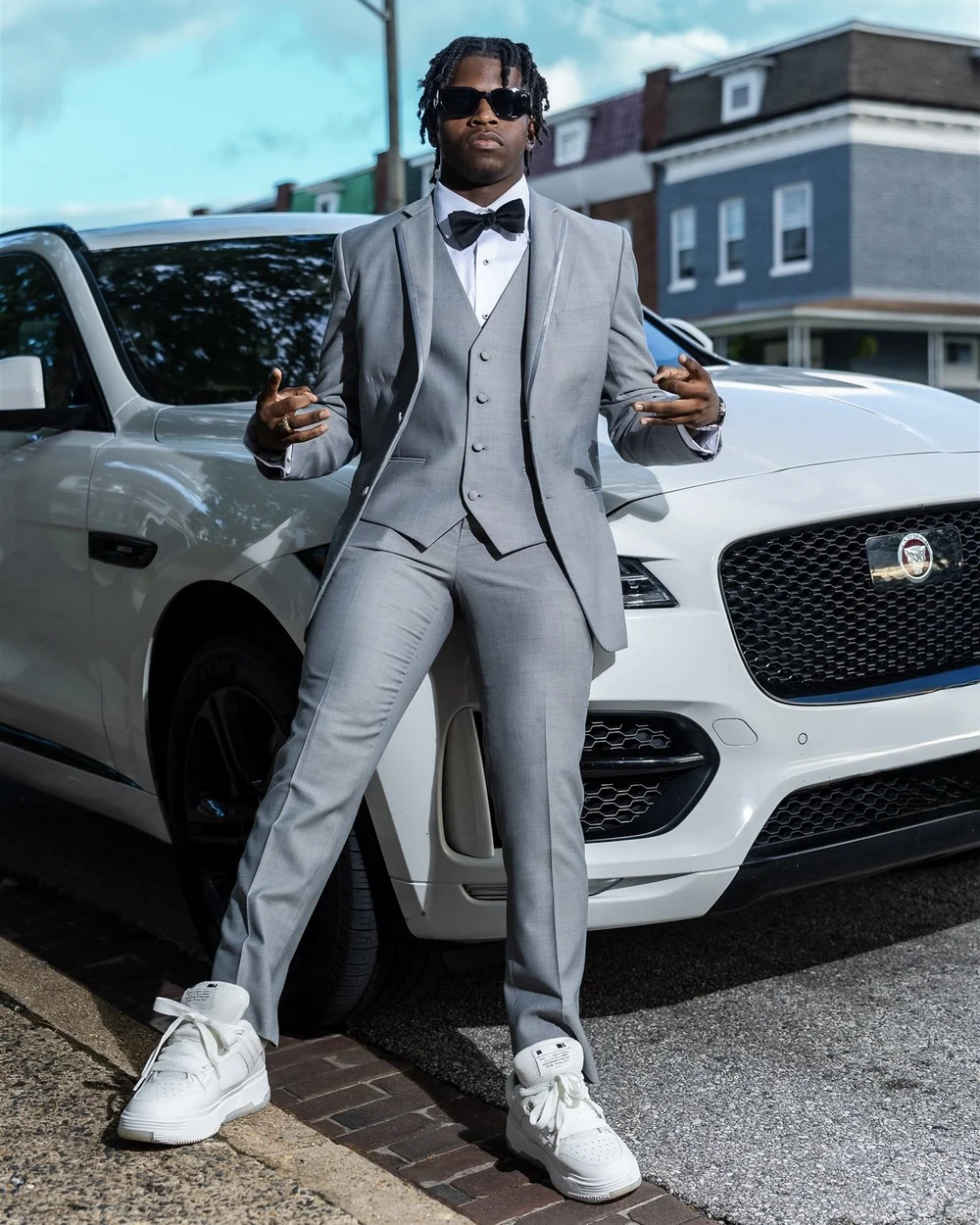 Prom sendoff in a grey suit beside a white SUV