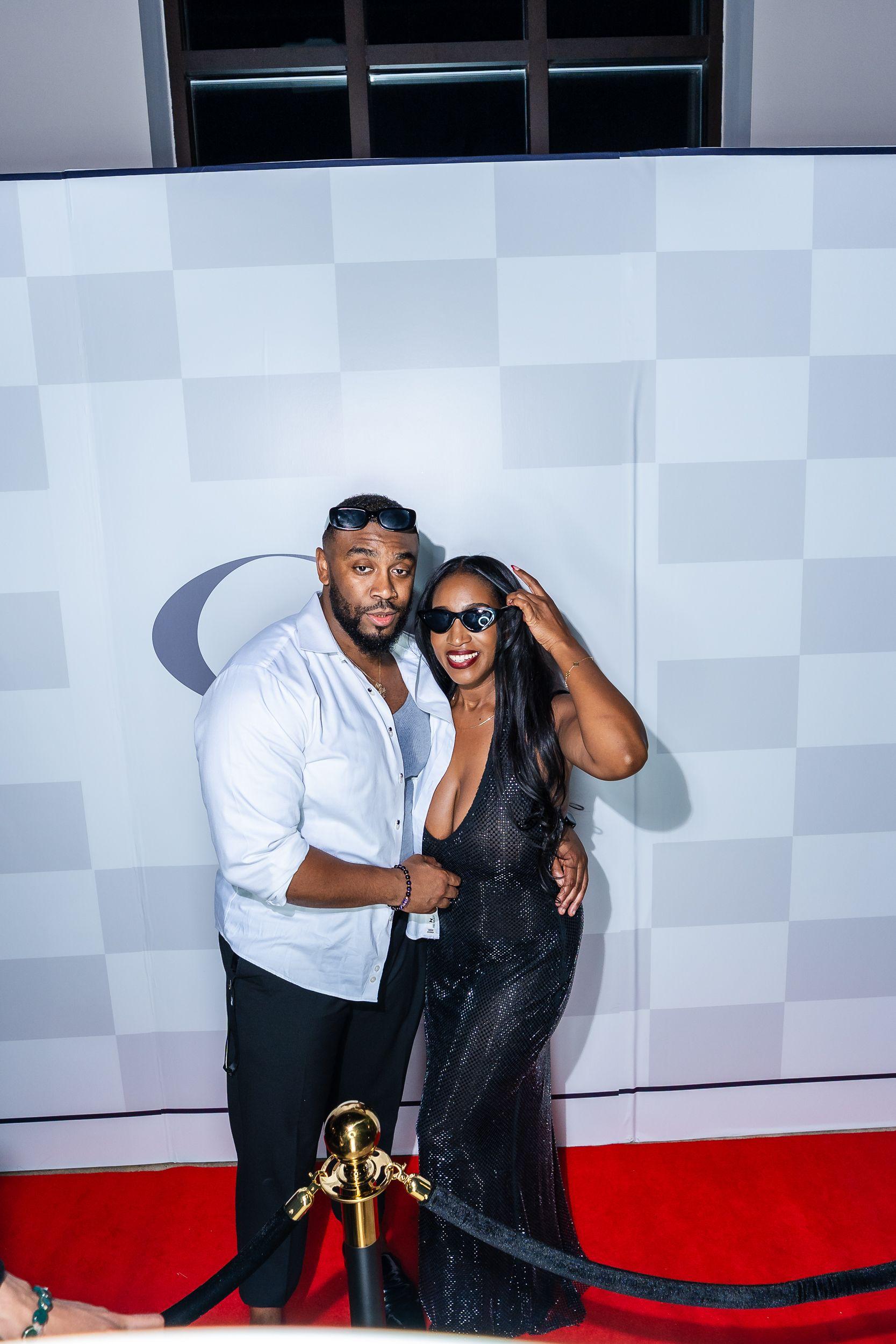 Couple posing together at the monogrammed backdrop at a Baltimore birthday party