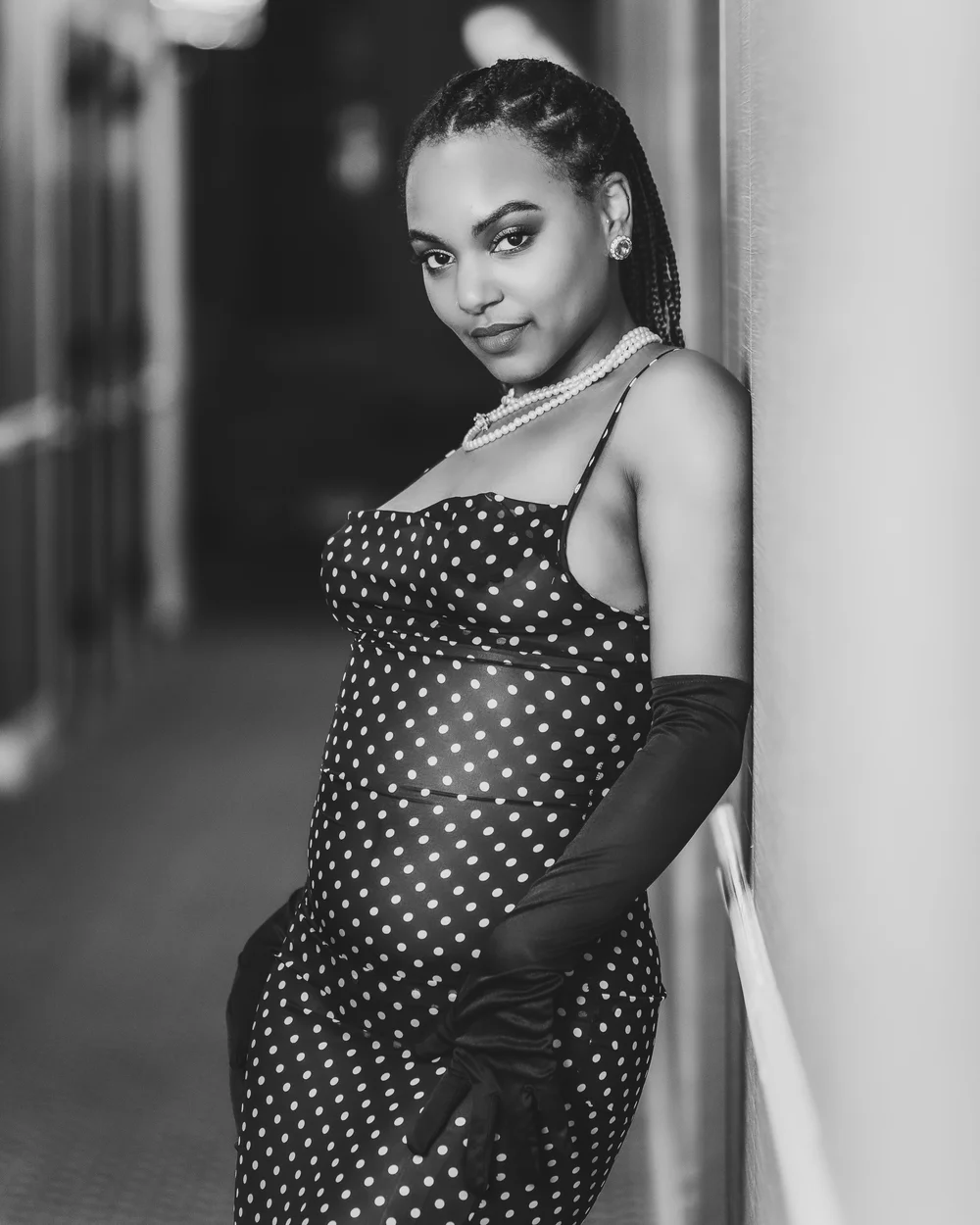 Black and white boudoir photography portrait of a pregnant woman in a polka-dot dress, by Marcus Gregory Photography