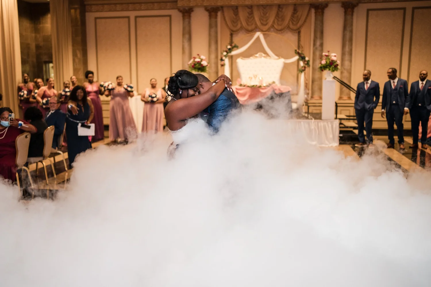 A bride enters her reception through a cloud of low-lying fog
