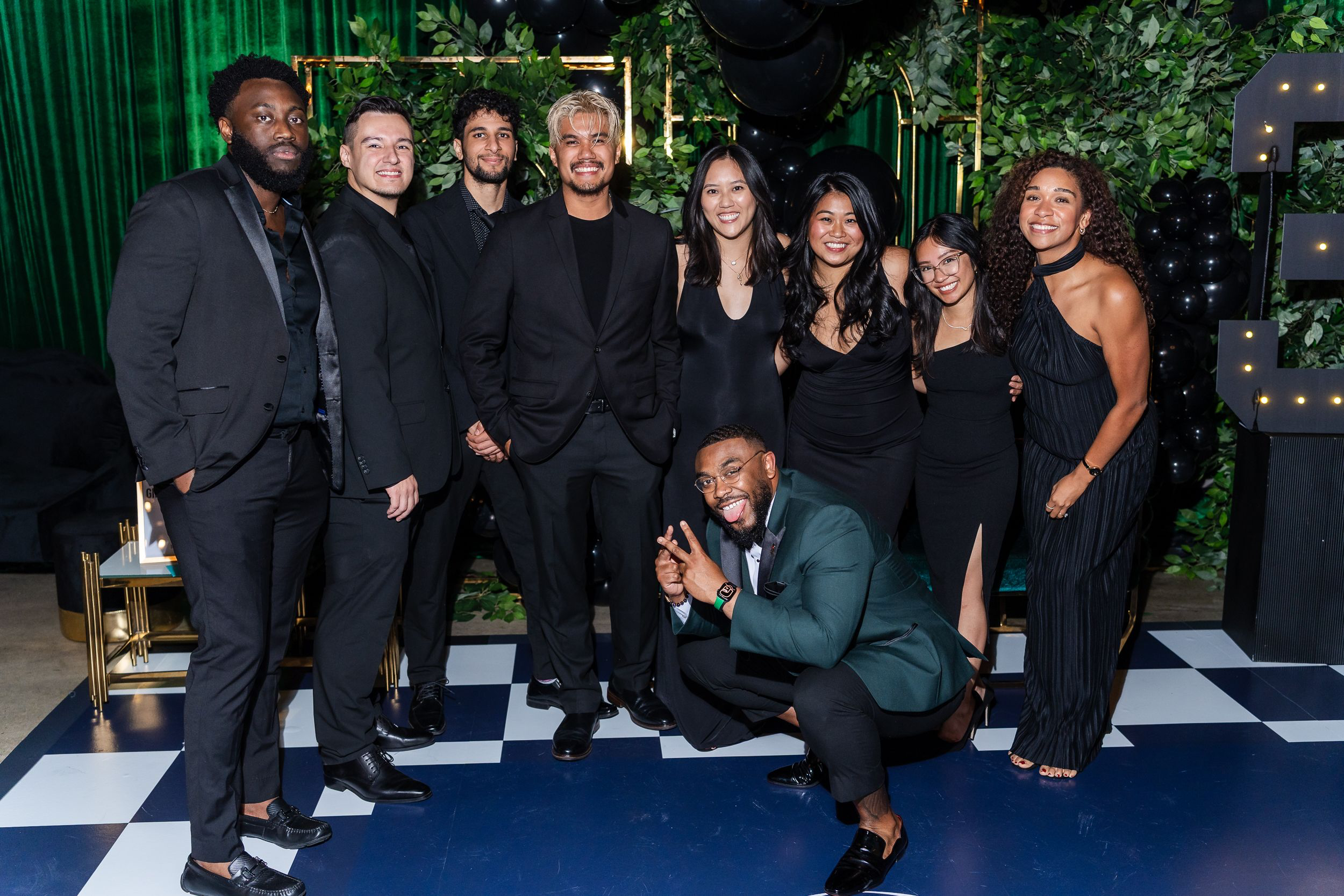 Group of friends gathered for a portrait at a black-and-gold birthday party