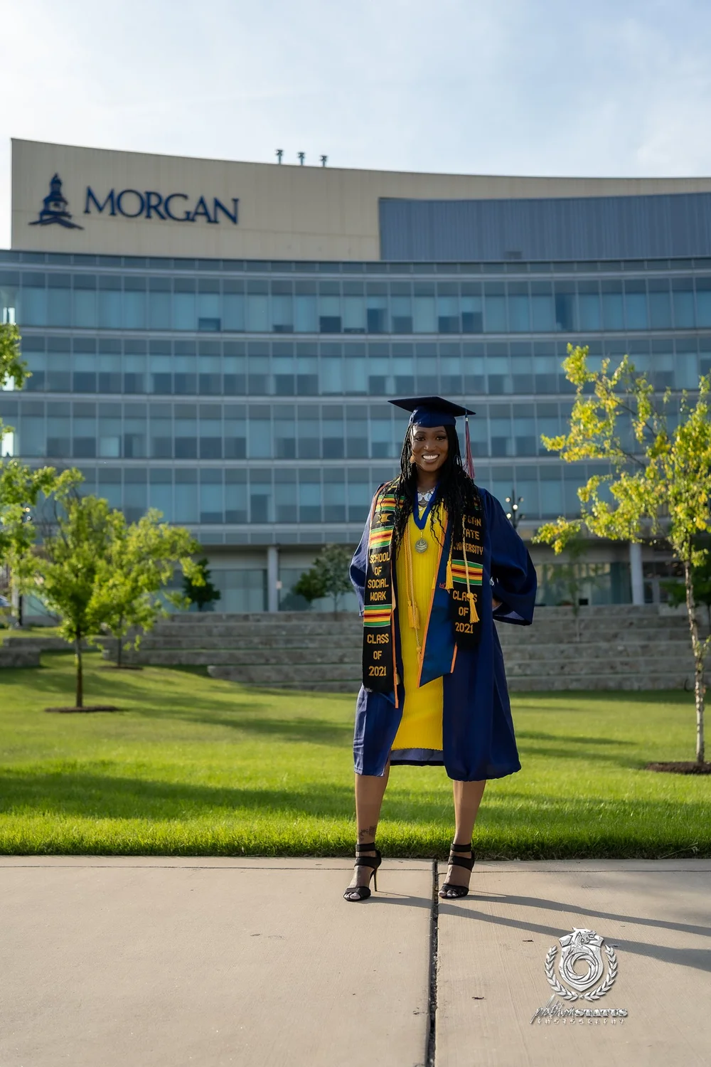 Graduate on a campus walkway in cap and gown