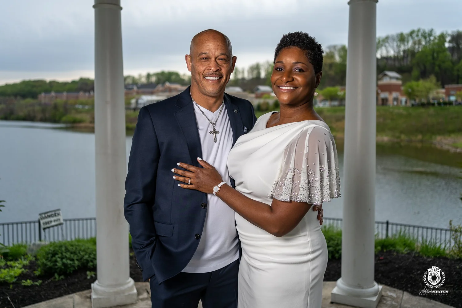 A newly married couple together beside the water