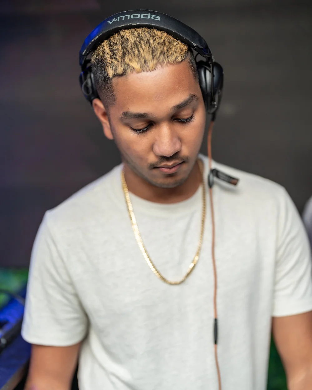 Guest in white with a gold chain at an all-white affair