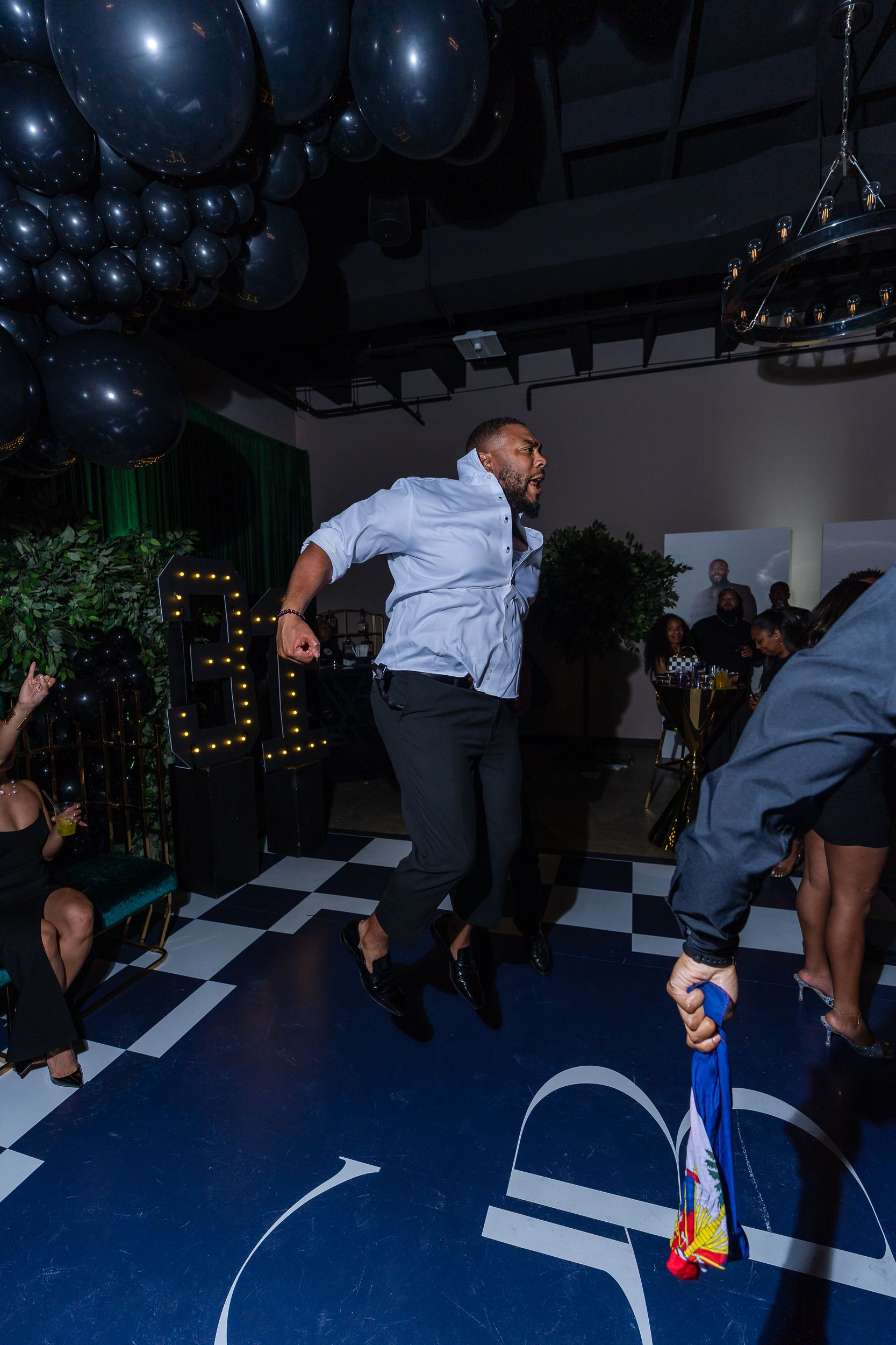 Guest jumping mid-air on the checkered dance floor