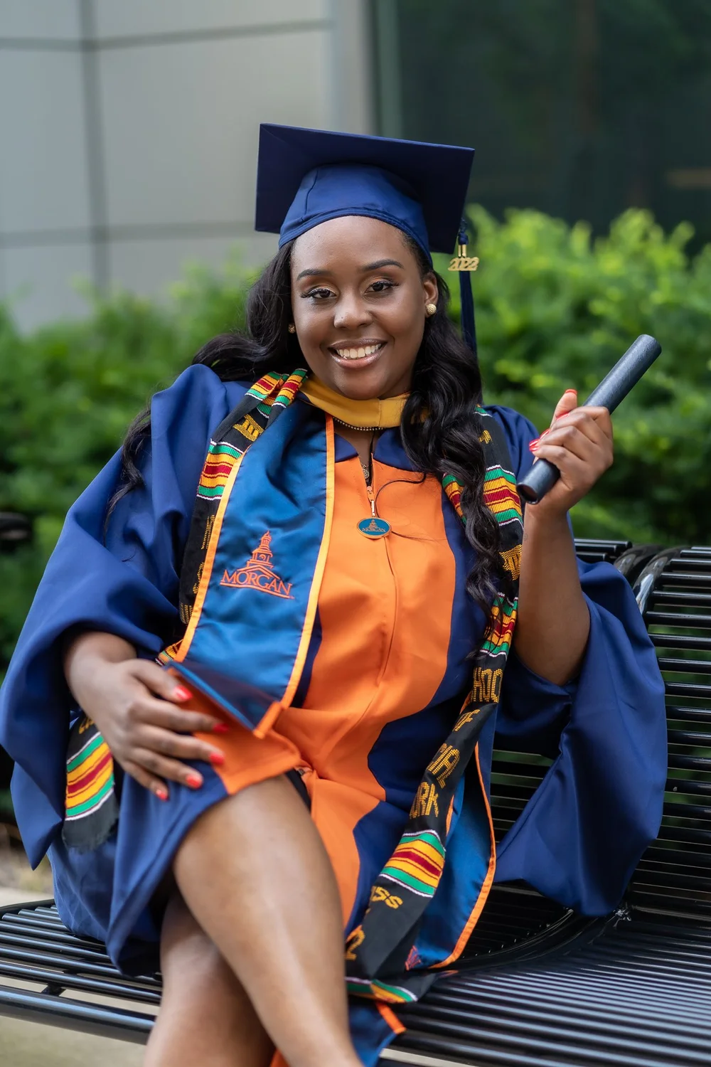 Graduate wearing an orange and navy stole