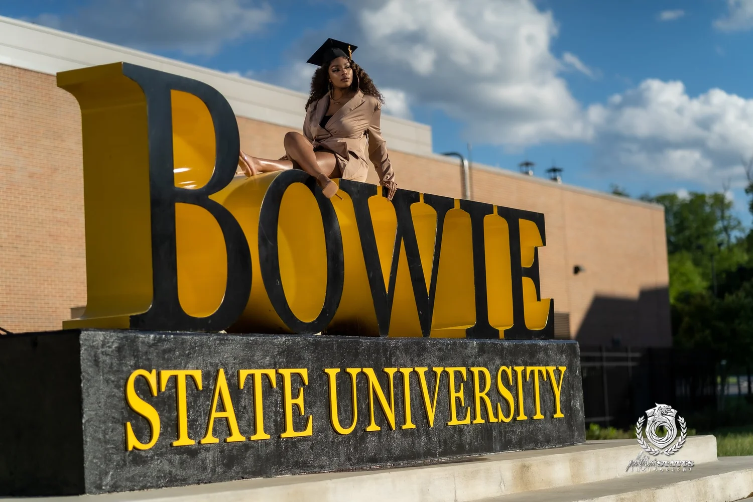 Graduate seated on the Bowie State University campus lettering during a senior portrait session