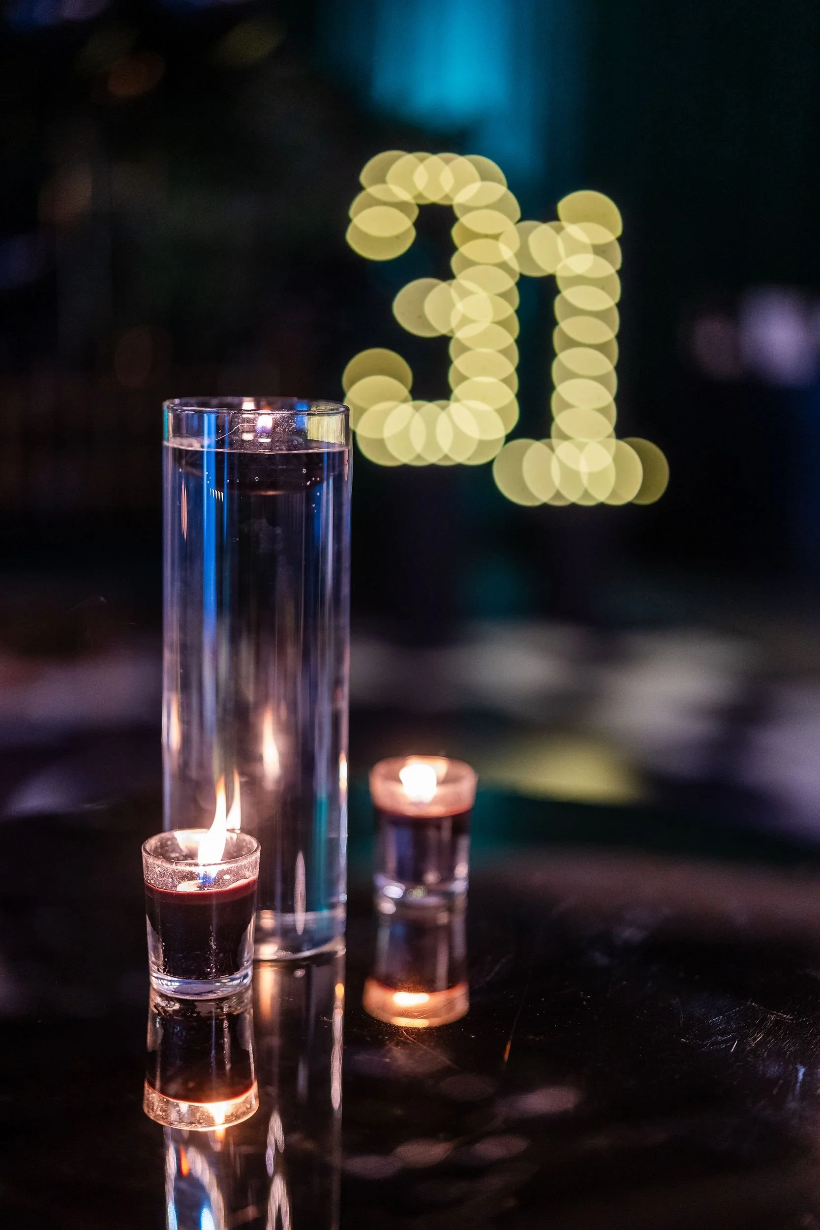 Gold 31 balloon numbers and a candlelit cocktail table at a milestone birthday celebration