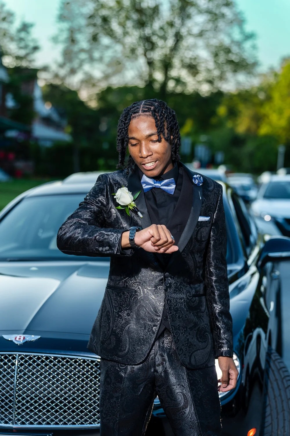 Prom sendoff portrait in a tuxedo holding a rose