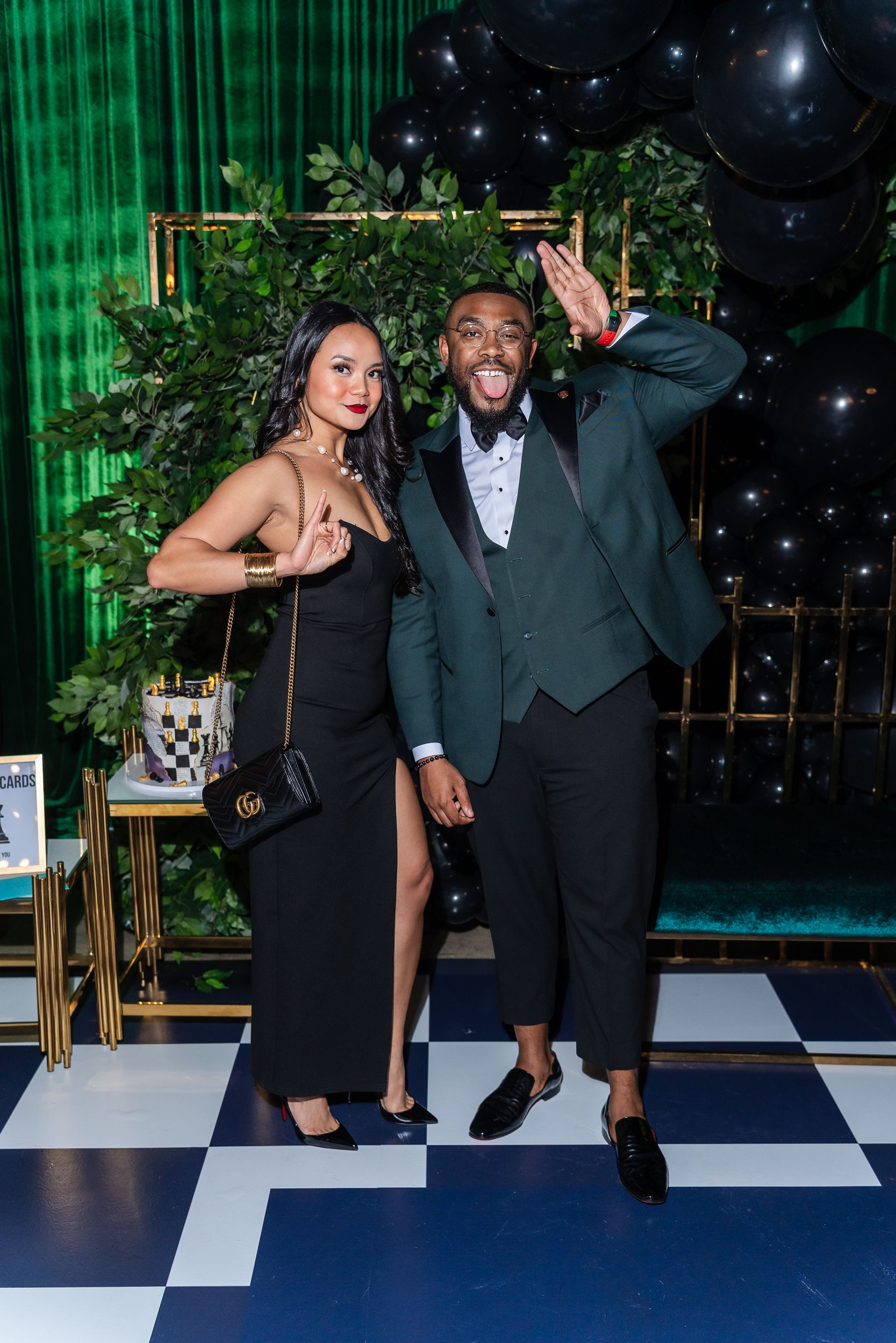 Couple posing beside the balloon backdrop at a 31st birthday party