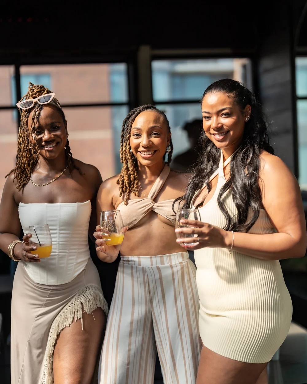 Three friends raising their glasses at a summer day party