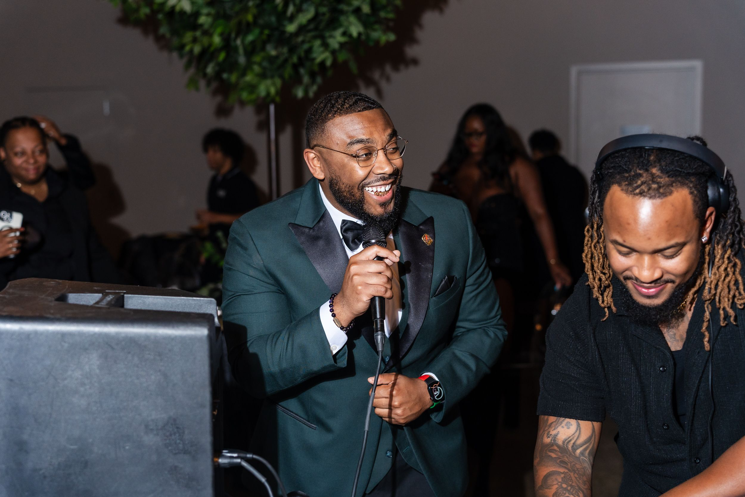 Host speaking into a microphone during a toast at a Baltimore birthday party