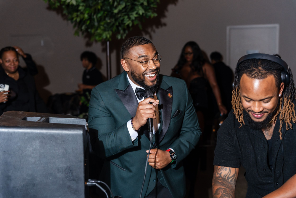 Host speaking into a microphone during a toast at a Baltimore birthday party