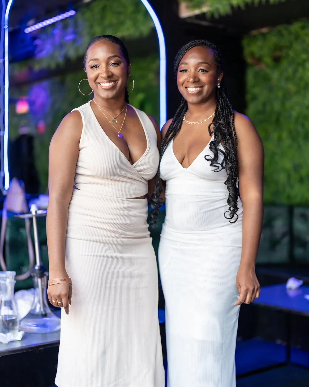 Two guests posing in white at a Baltimore summer party