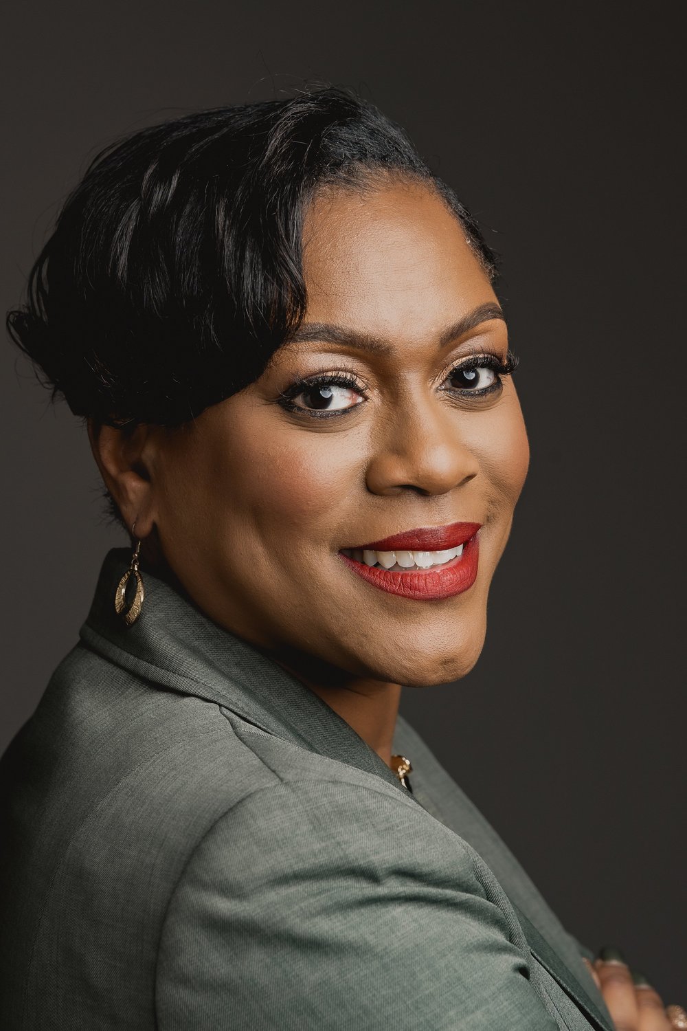Professional business headshot portrait of a woman on a dark studio backdrop, by Marcus Gregory Photography