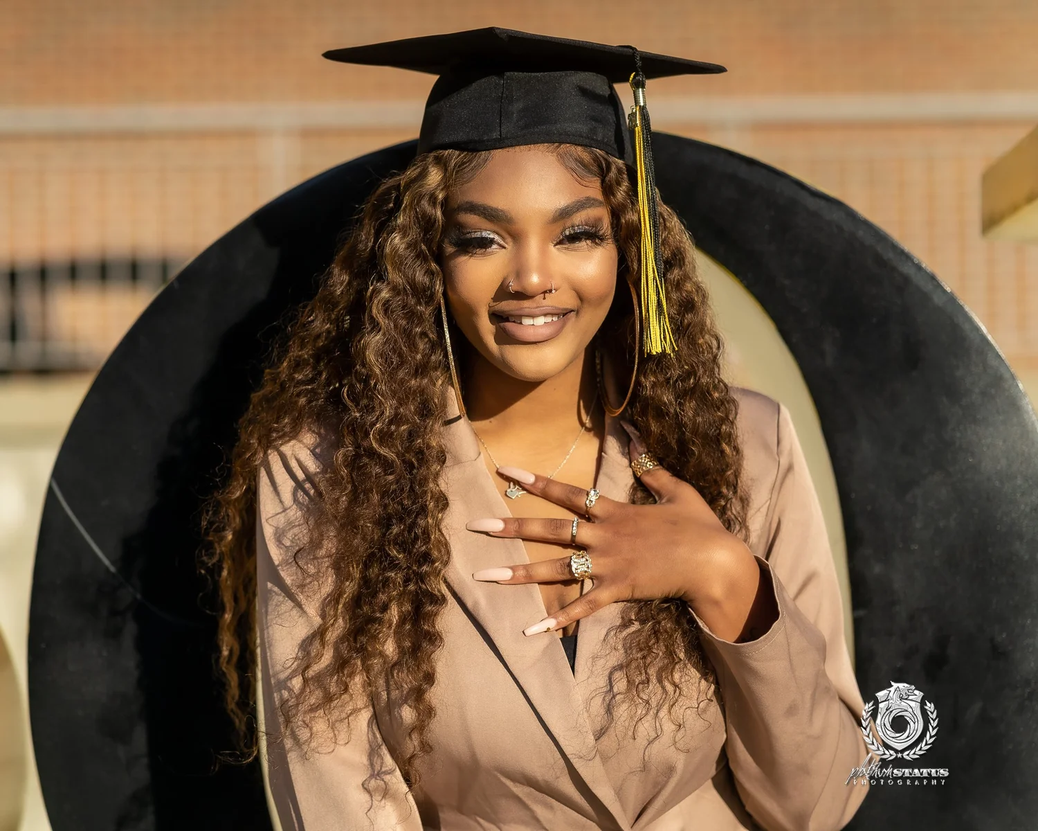 College graduate in cap and gown smiling in golden light during a senior portrait session in Maryland