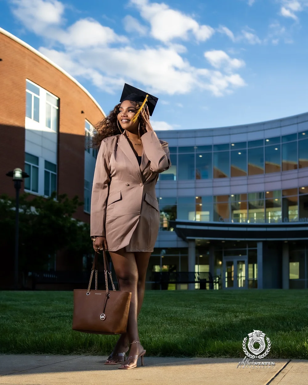 Graduate in a tan coat on campus in Maryland